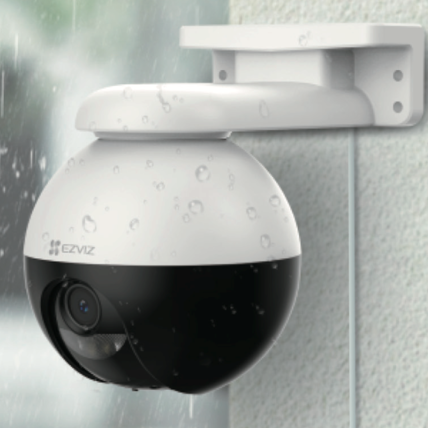 Biało-czarna kamera bezpieczeństwa zamontowana na ścianie, z widocznymi kroplami deszczu na jej powierzchni.