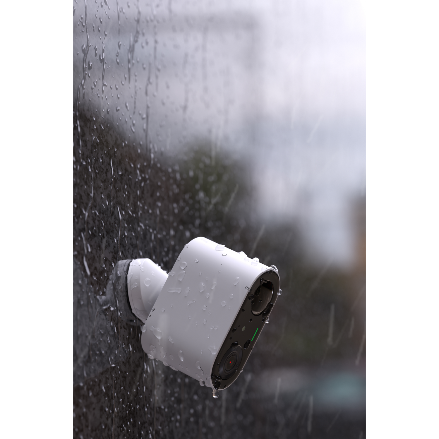 Biała kamera bezpieczeństwa zamontowana na ścianie, mokra od kropel deszczu. Ciemne tło z rozmytym deszczem.