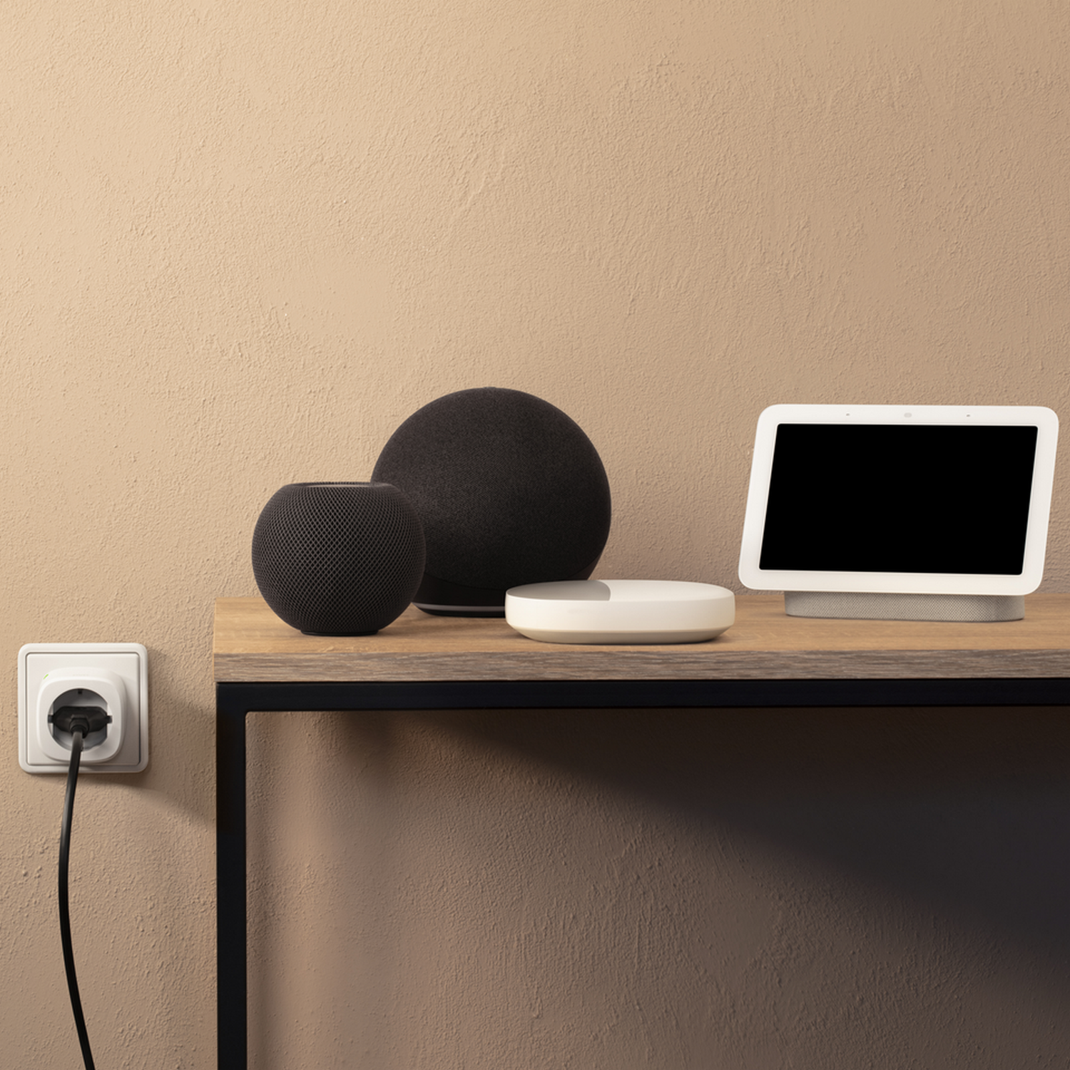 Smart-Home-Geräte auf einem Holzregal, darunter Lautsprecher und ein Smart-Display, vor einer beigen Wand.