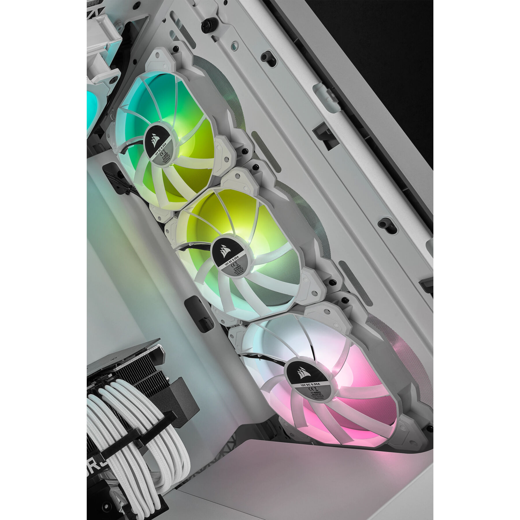 Trzy wentylatory RGB zainstalowane w obudowie PC. Emitują różne kolory i mają logo Corsair.