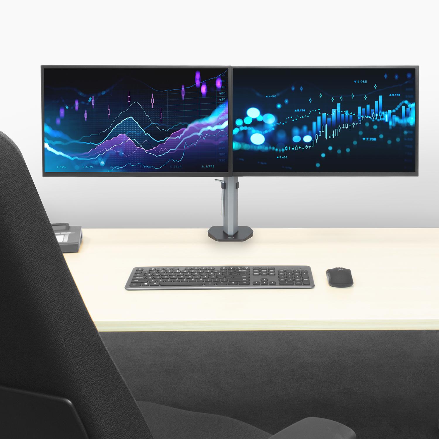 Zwei Monitore mit Diagrammen. Tastatur, Maus auf dem Schreibtisch. Stuhl im Vordergrund.