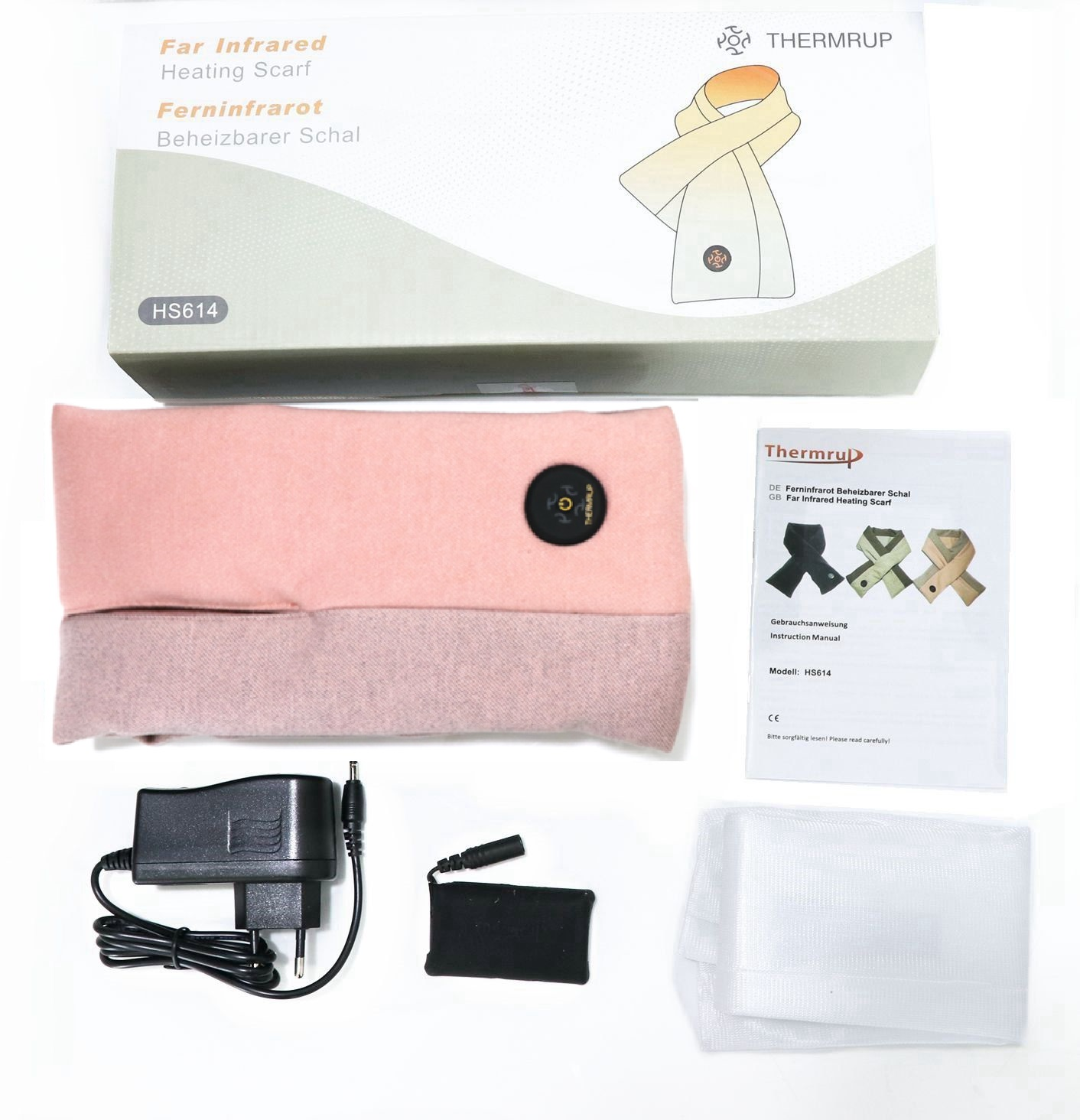 Schachtel mit Schal, Ladekabel und anderem Zubehör. Rosa und grauer Schal, weißer Hintergrund.