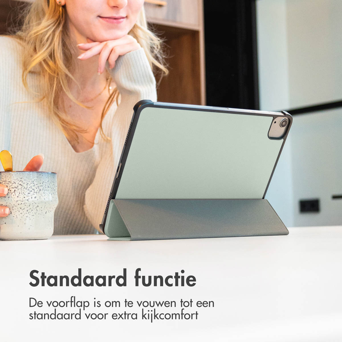 Femme blonde, iPad avec étui et support, et une tasse à café sur une table blanche. Texte en bas.
