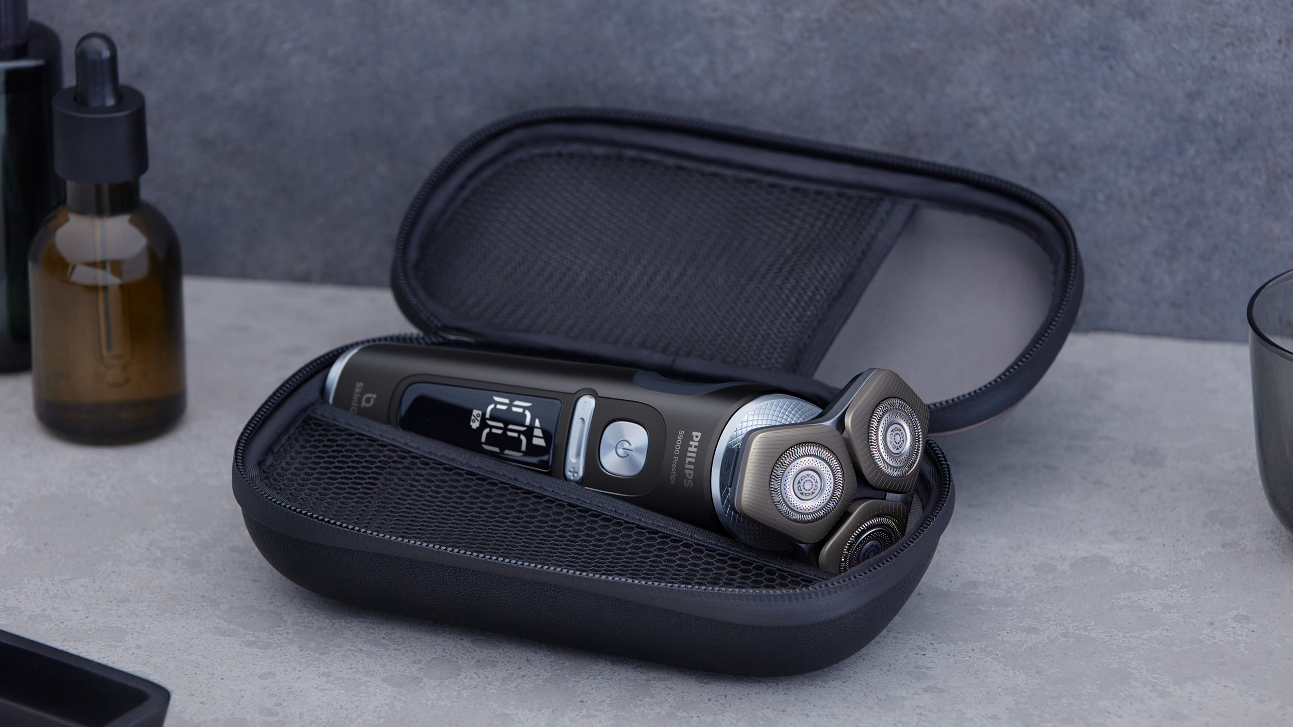 Elektrorasierer in einem schwarzen Etui. Der Rasierer ist silber und schwarz.