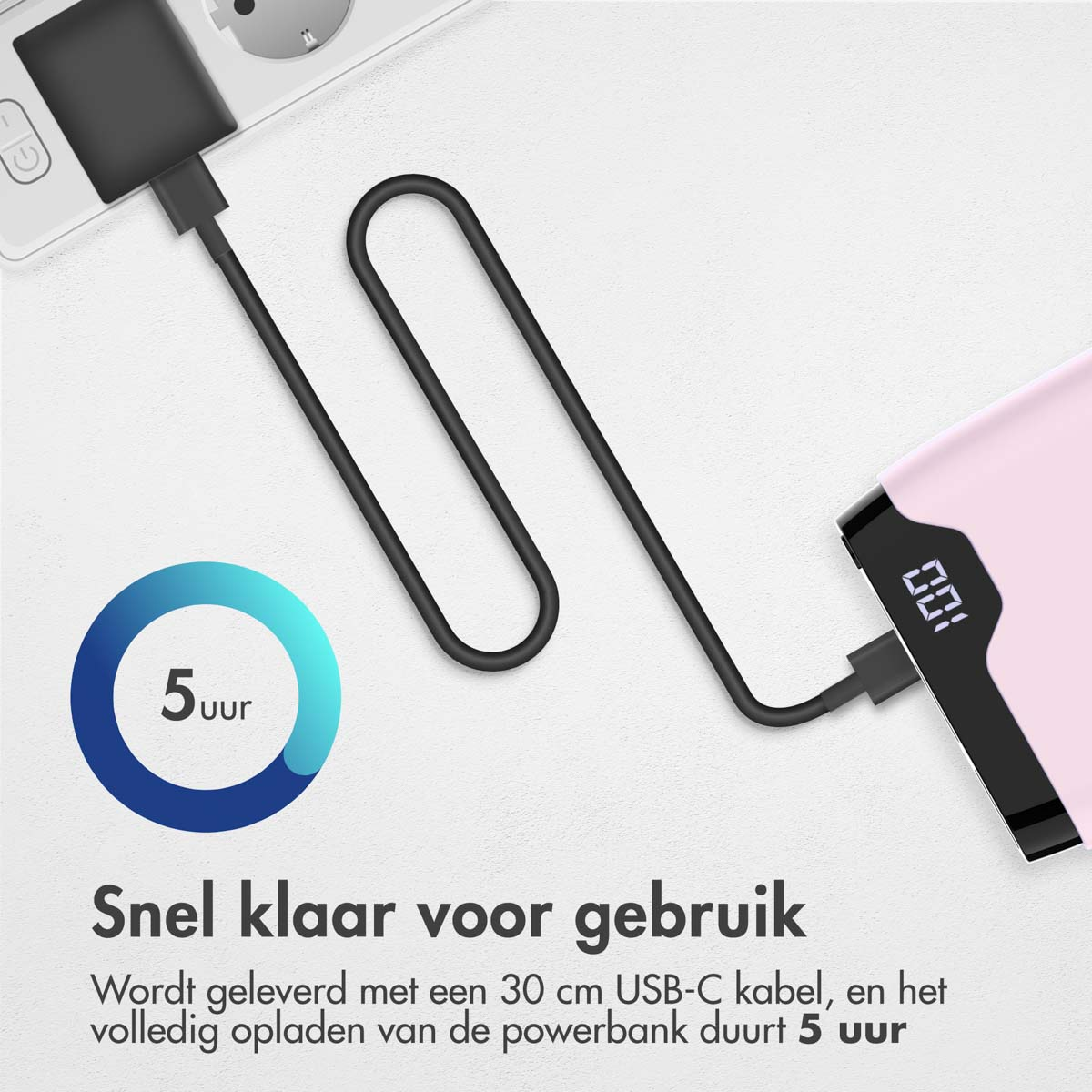 Une banque d'alimentation rose se charge via un câble USB-C noir.