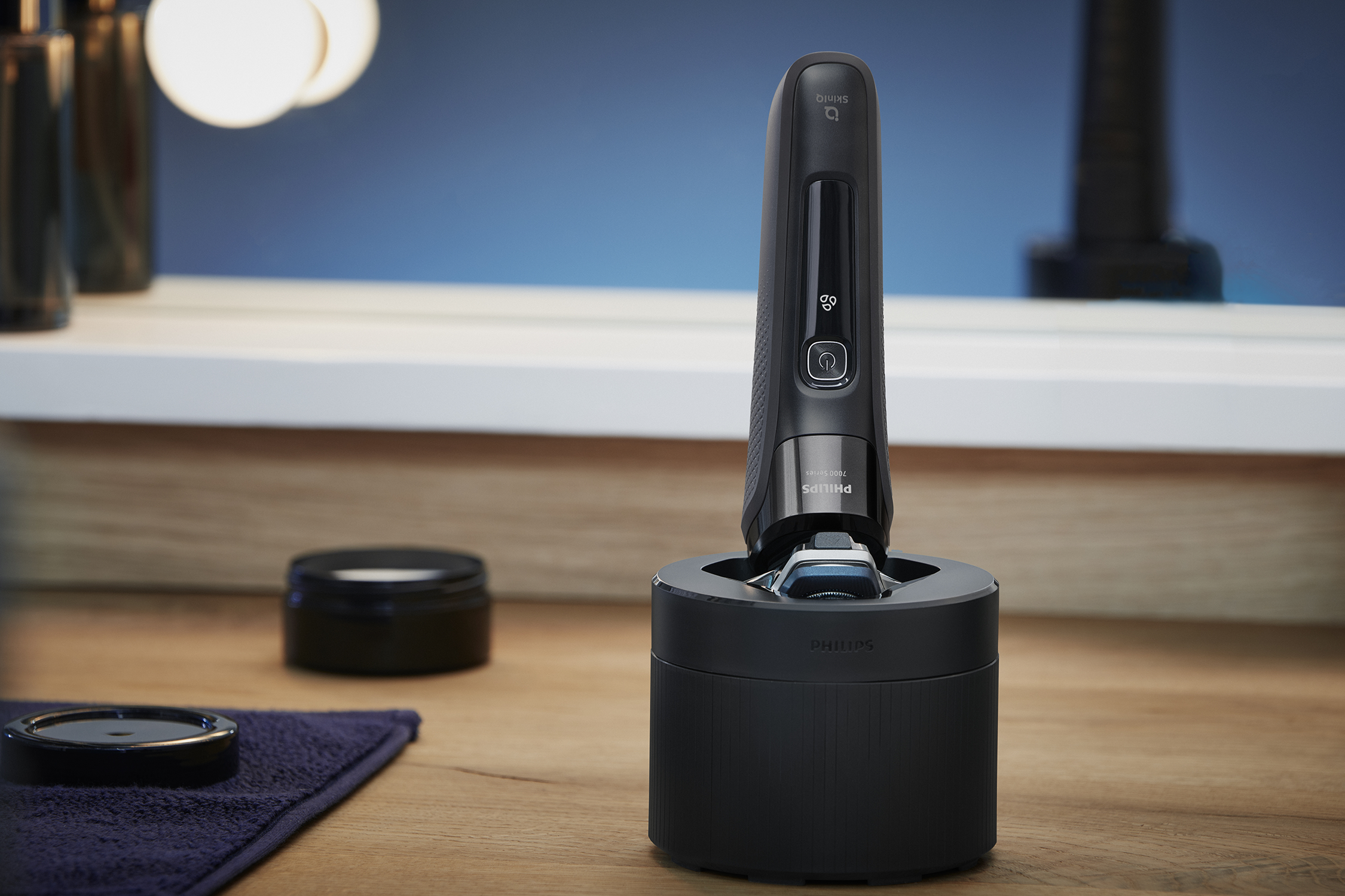 Rasoir Philips noir dans une base de chargement noire. Surface en bois, arrière-plan flou.