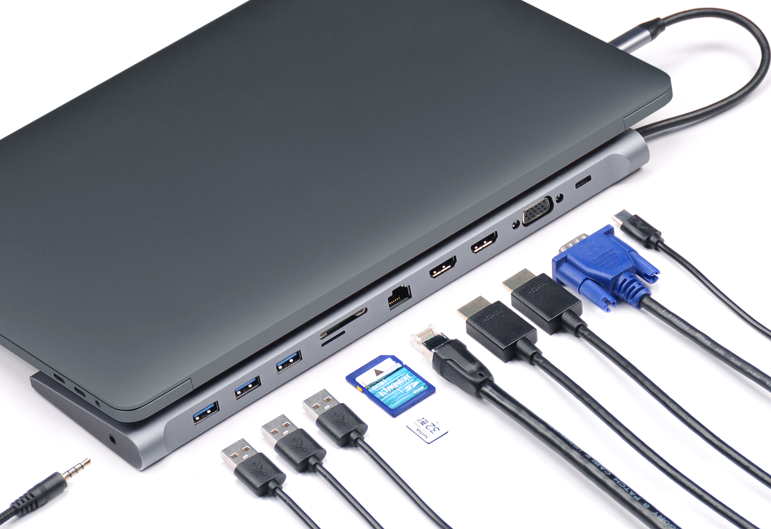 Laptop mit mehreren Anschlüssen und angeschlossenen Kabeln auf weißer Oberfläche. SD-Karte und USB-Laufwerke sichtbar.