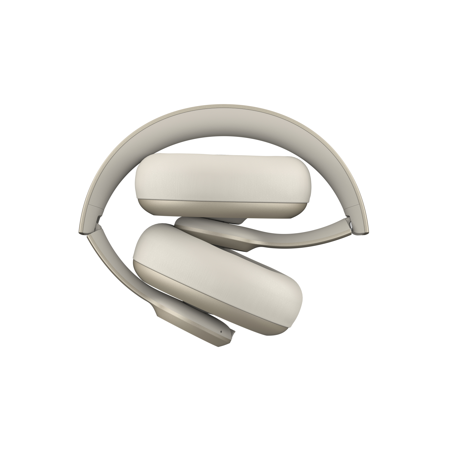 Beżowe słuchawki, złożone. Nauszniki i pałąk są beżowe. Na ciemnym tle.