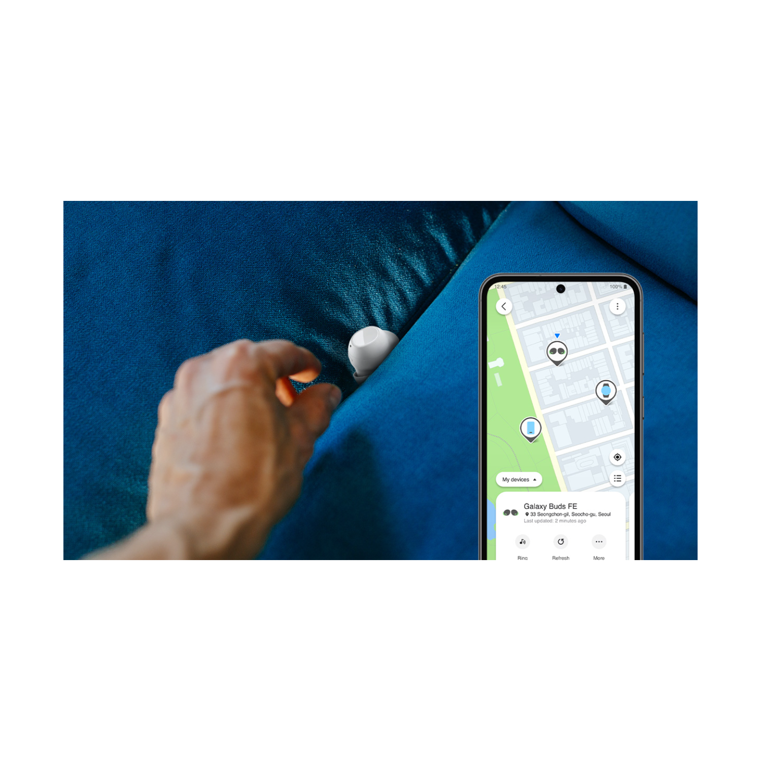 Dłoń sięgająca po białe Galaxy Buds PE w niebieskiej kanapie.