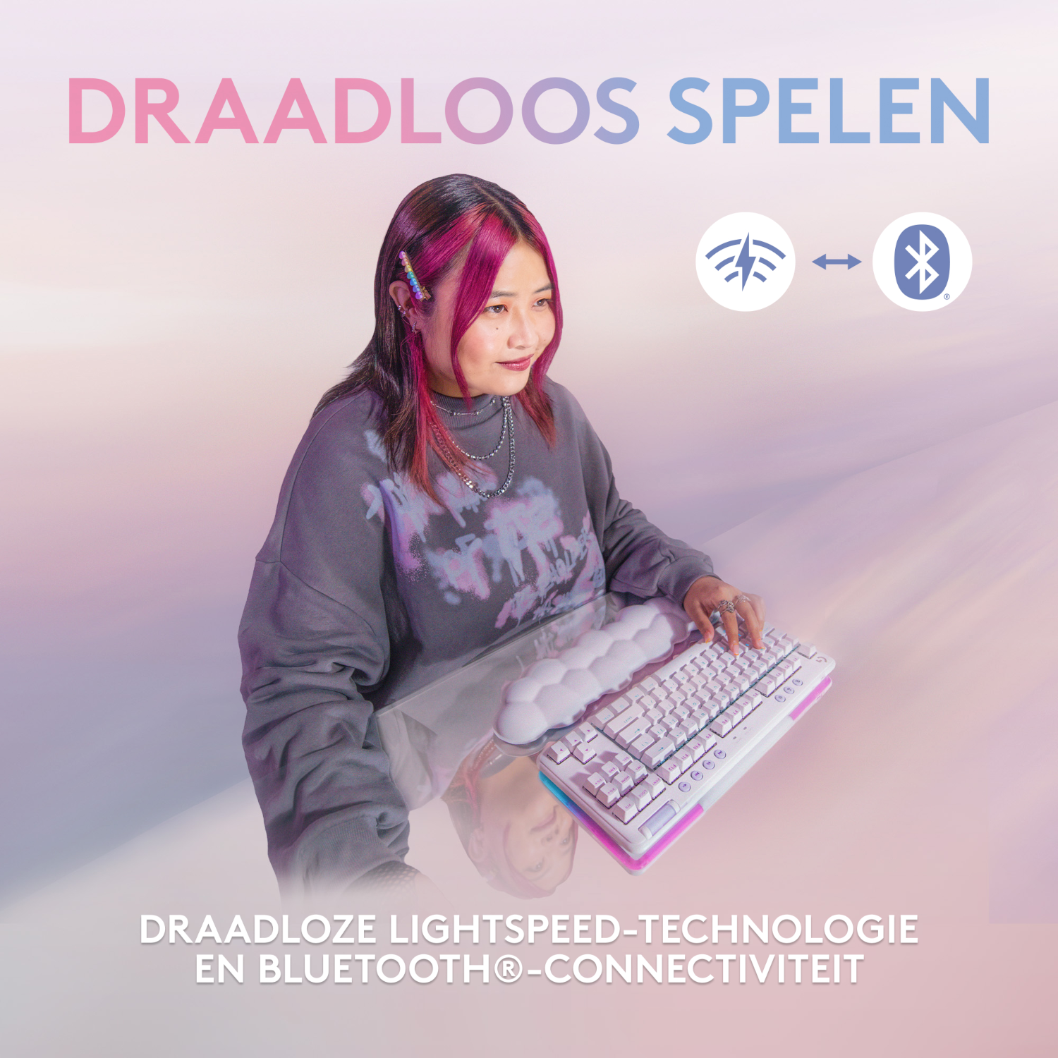 Donna con capelli rosa usa tastiera bianca. Testo DRAADLOOS SPELEN. Simboli wireless.