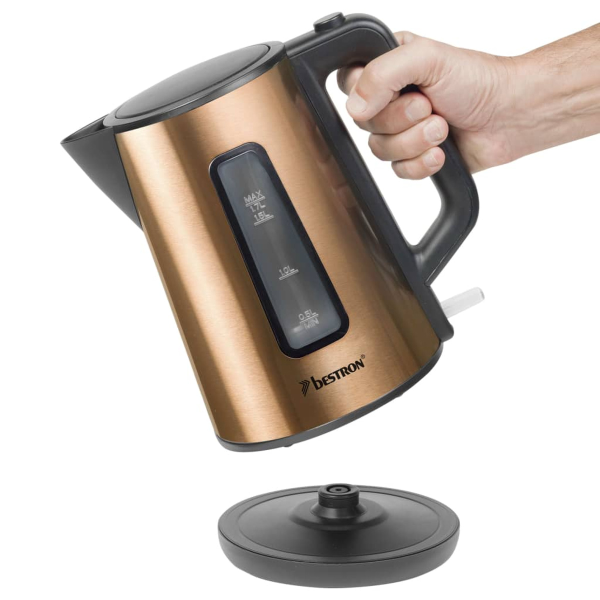 Un bollitore elettrico color rame con manico e base neri, tenuto da una mano.
