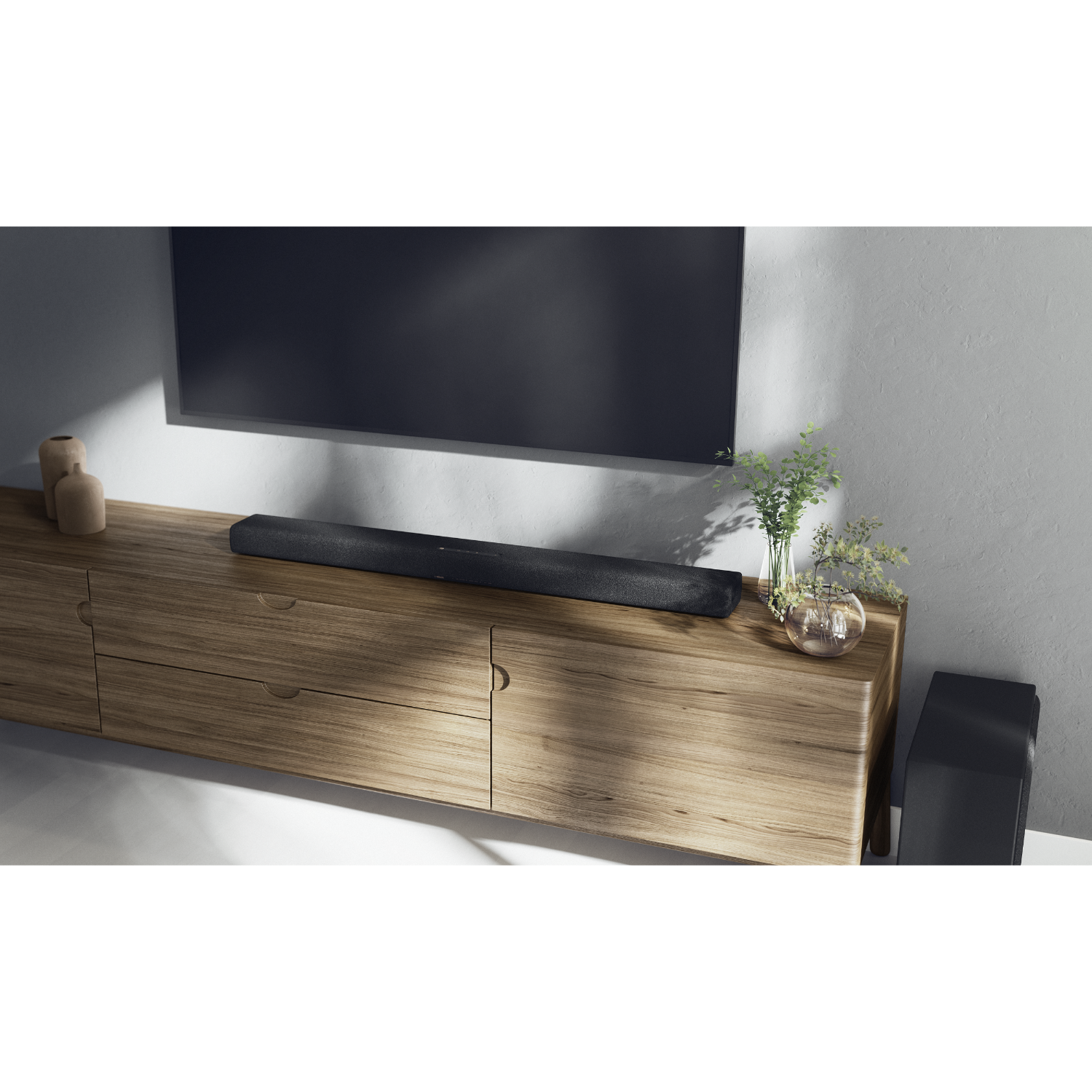 Soundbar op een houten kast, tv-scherm erboven, met planten in een glazen vaas.