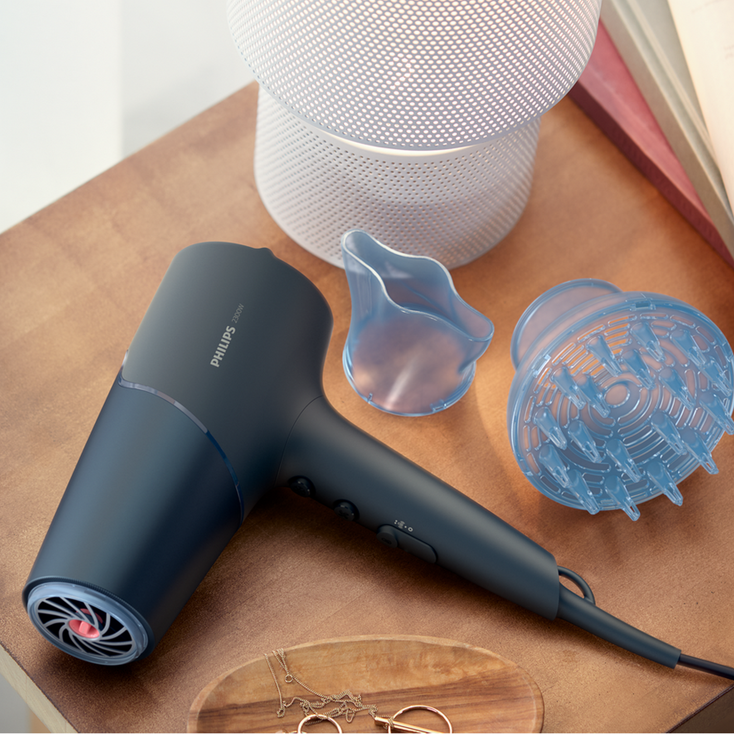 Suszarka do włosów z akcesoriami na drewnianej powierzchni. Akcesoria: koncentrator i dyfuzor.