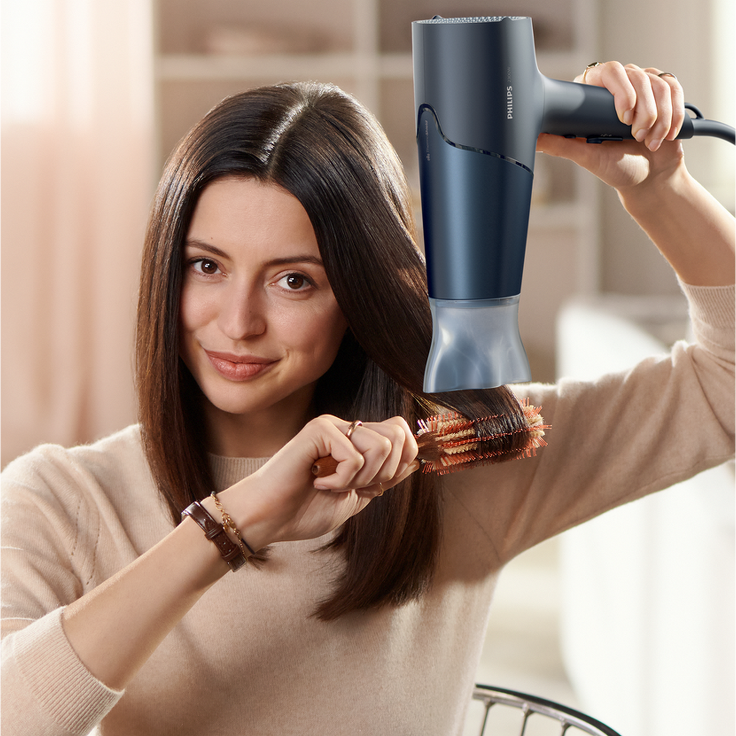 Kobieta używająca ciemnoniebieskiej suszarki do włosów na włosach z szczotką.
