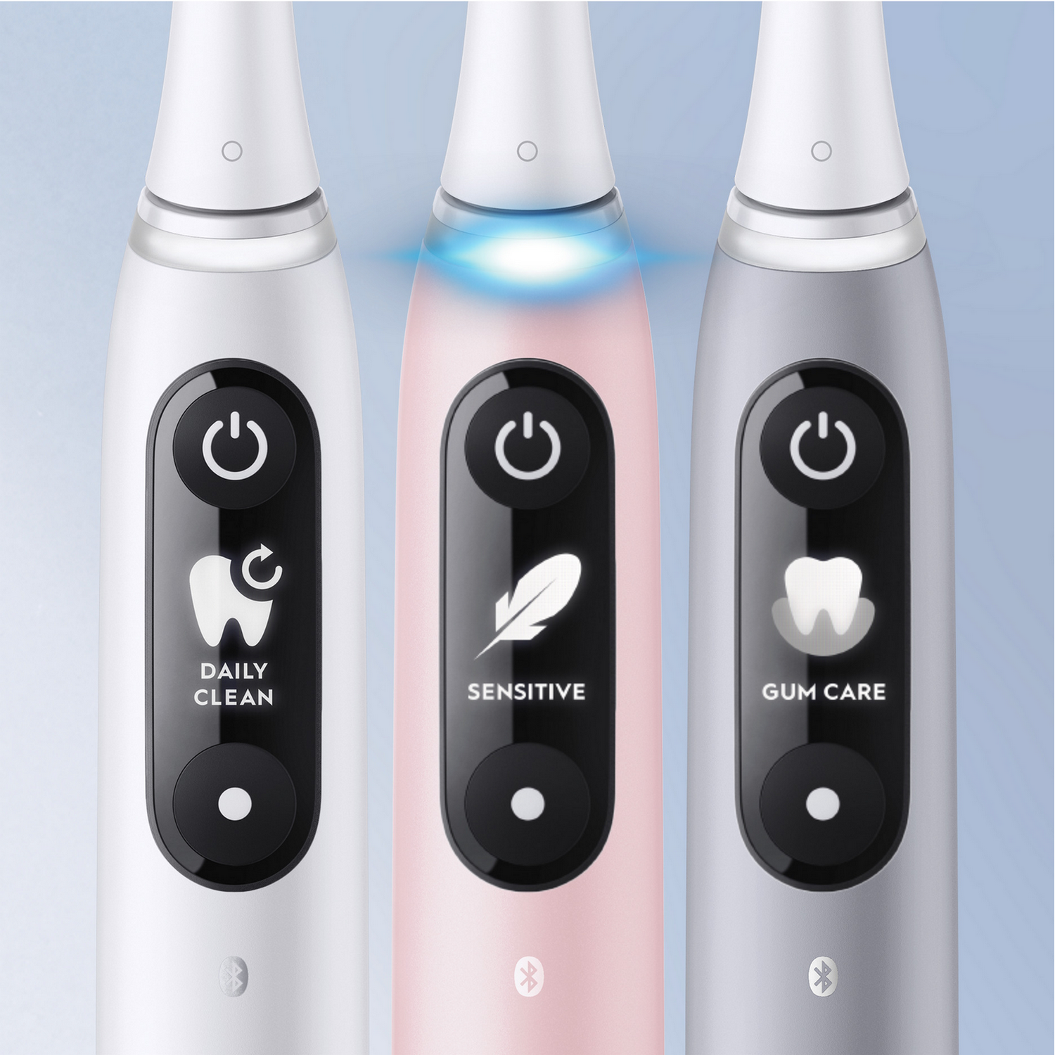 Trzy elektryczne szczoteczki do zębów, biała, różowa i srebrna, z różnymi trybami.
