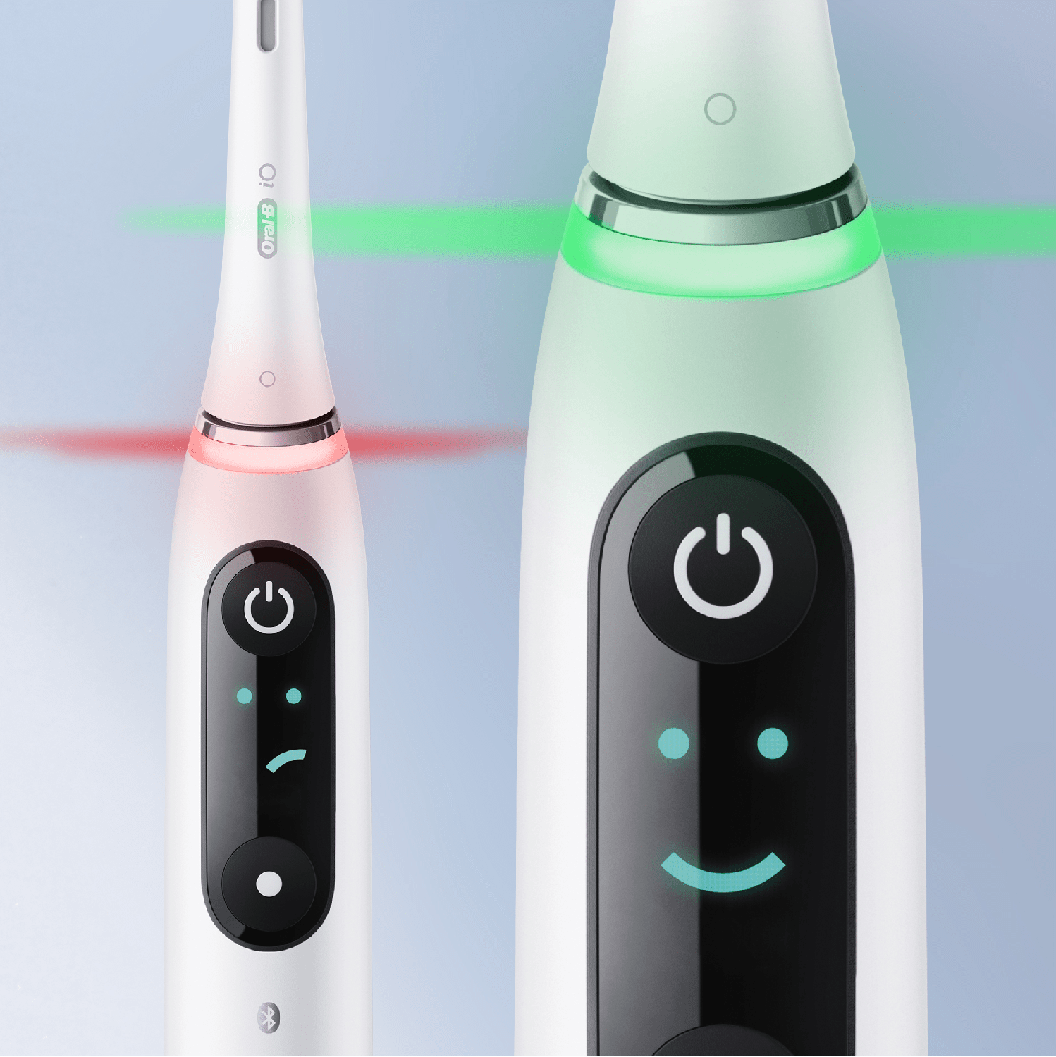 Primo piano di due spazzolini elettrici. Uno mostra luce rossa, l'altro verde.