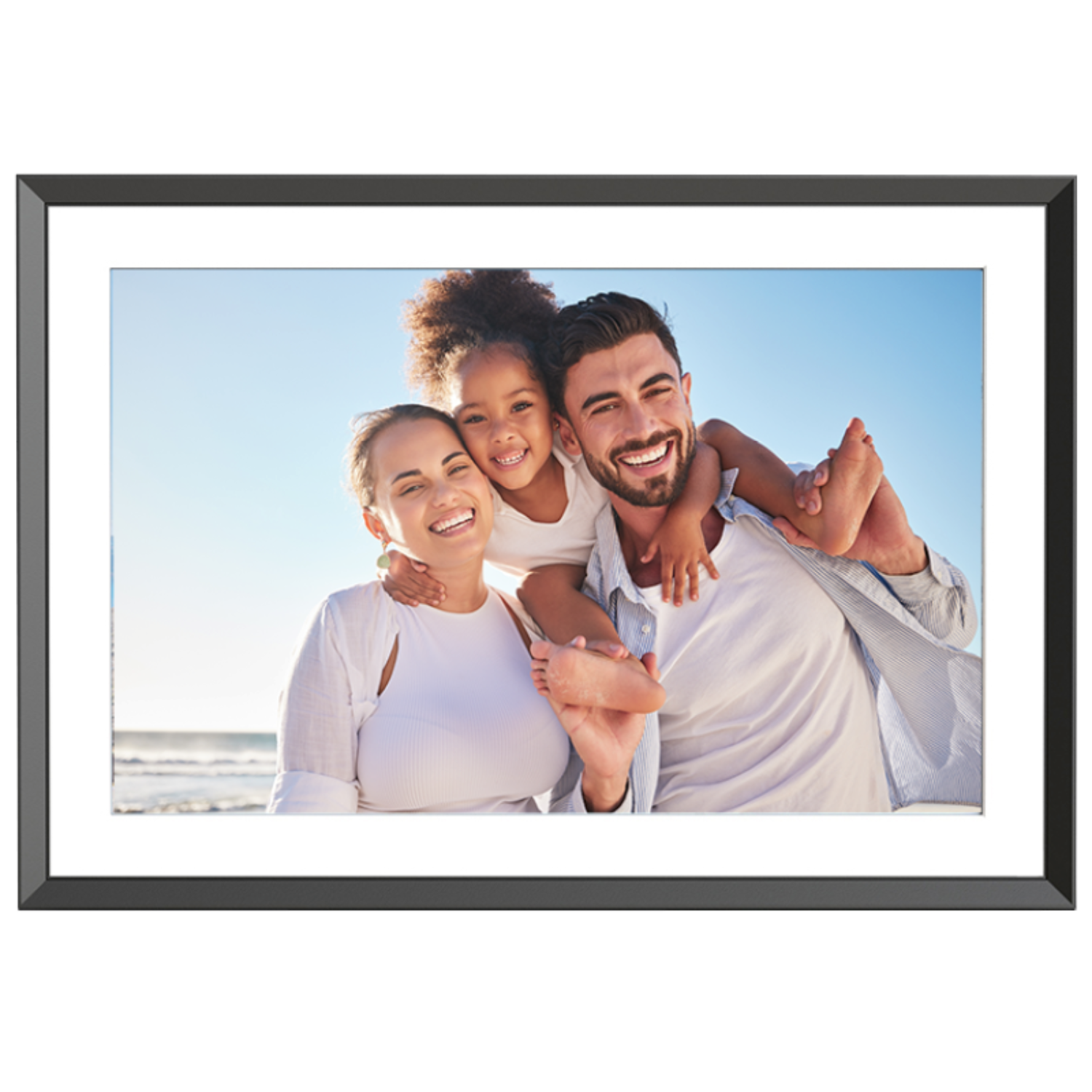 Rodzina trzyosobowa uśmiecha się do kamery. Mężczyzna niesie dziecko. Błękitne niebo i ocean w tle.