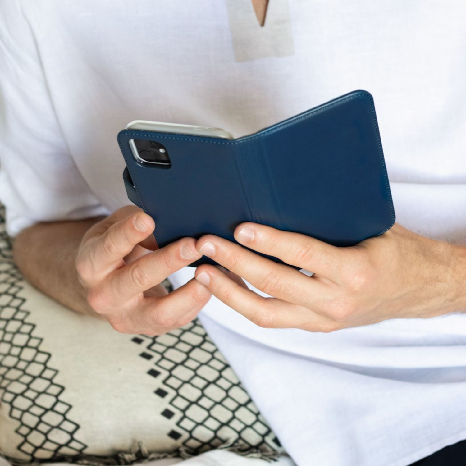 Ein Mann hält eine dunkelblaue Handyhülle. Das Telefon befindet sich in der Hülle.