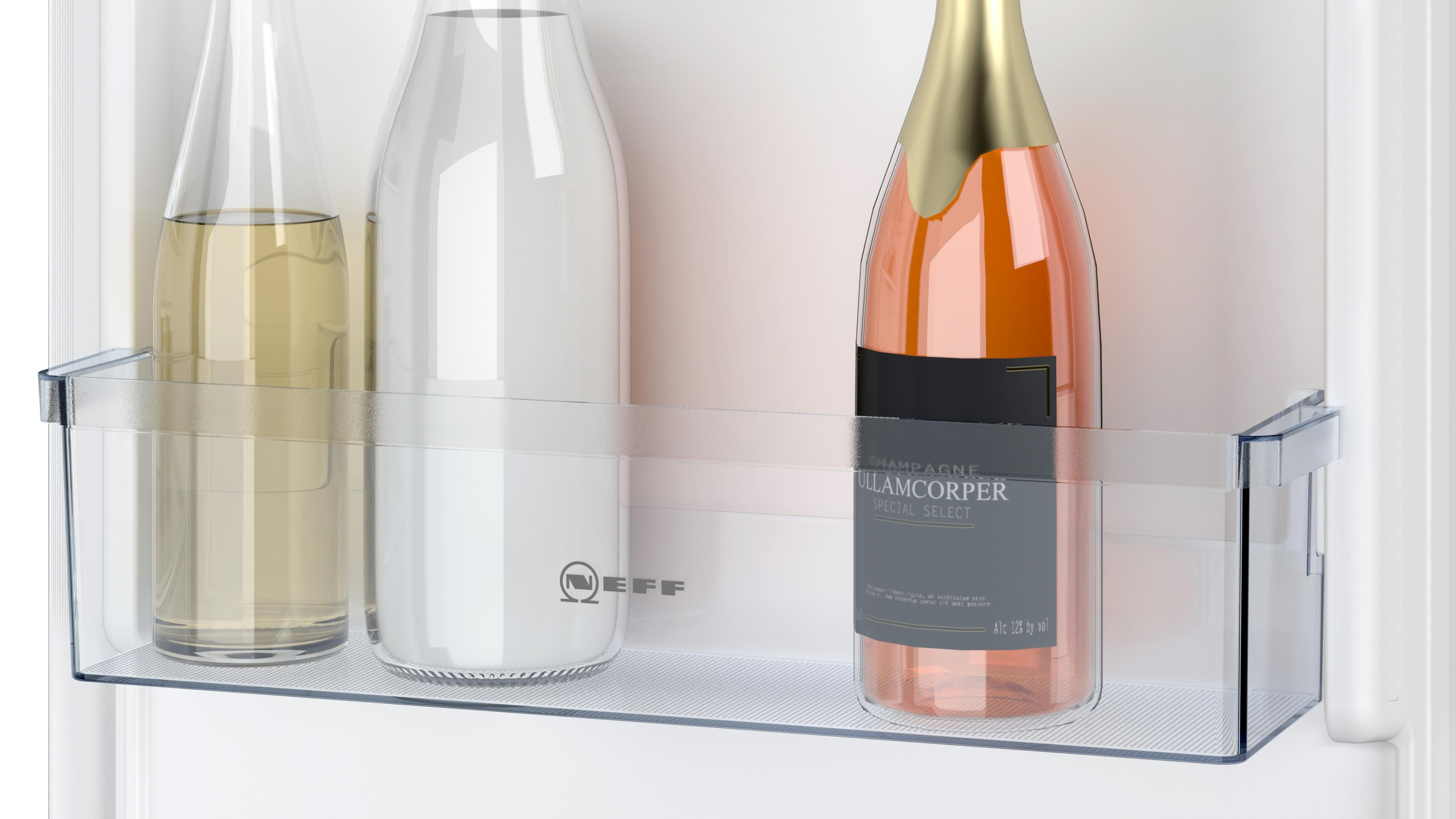 Een koelkastplank met flessen wijn en melk. Een champagnefles is prominent aanwezig.