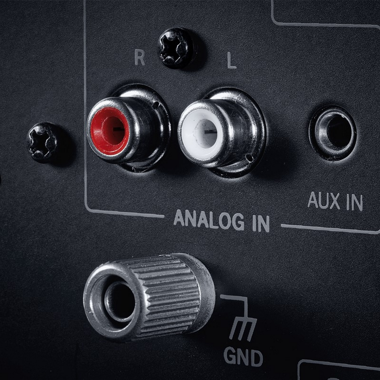 Primo piano degli ingressi audio neri su una superficie nera. Jack RCA rossi e bianchi.
