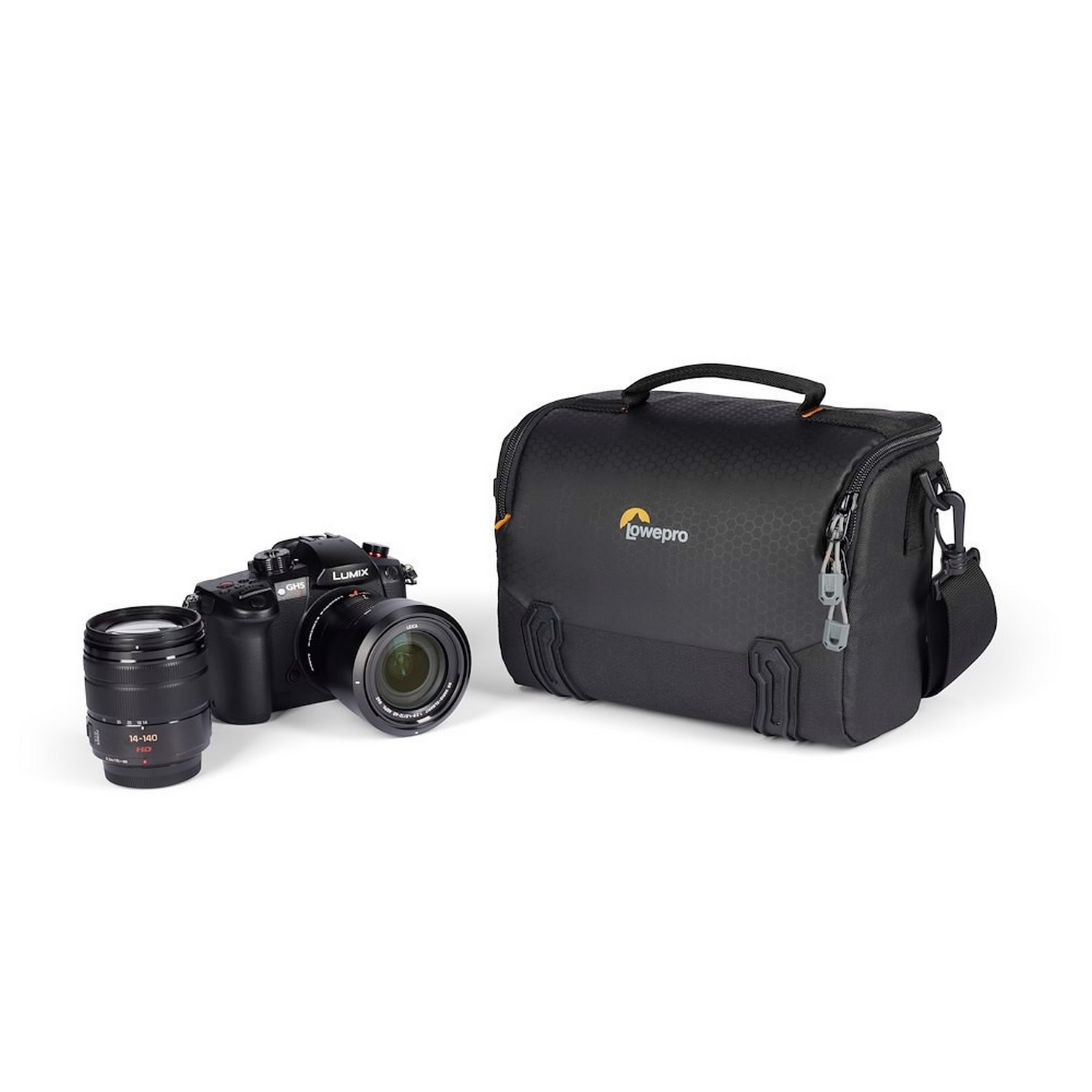 Camera, lens, and bag on a white surface. The camera is black, with a lens attached and another lens beside it. The bag is black.