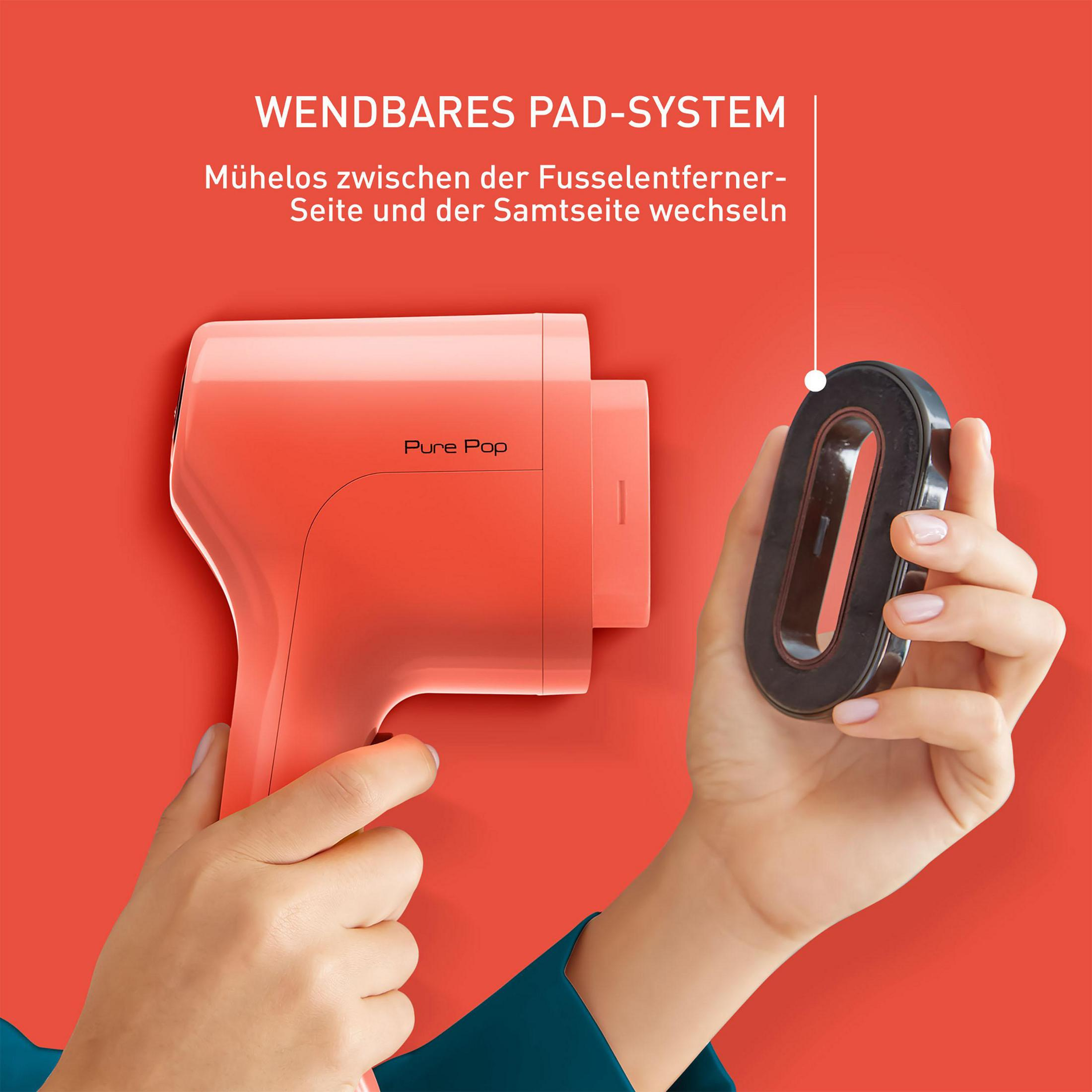 Osoba trzyma różowe urządzenie i czarny załącznik. Czerwone tło.