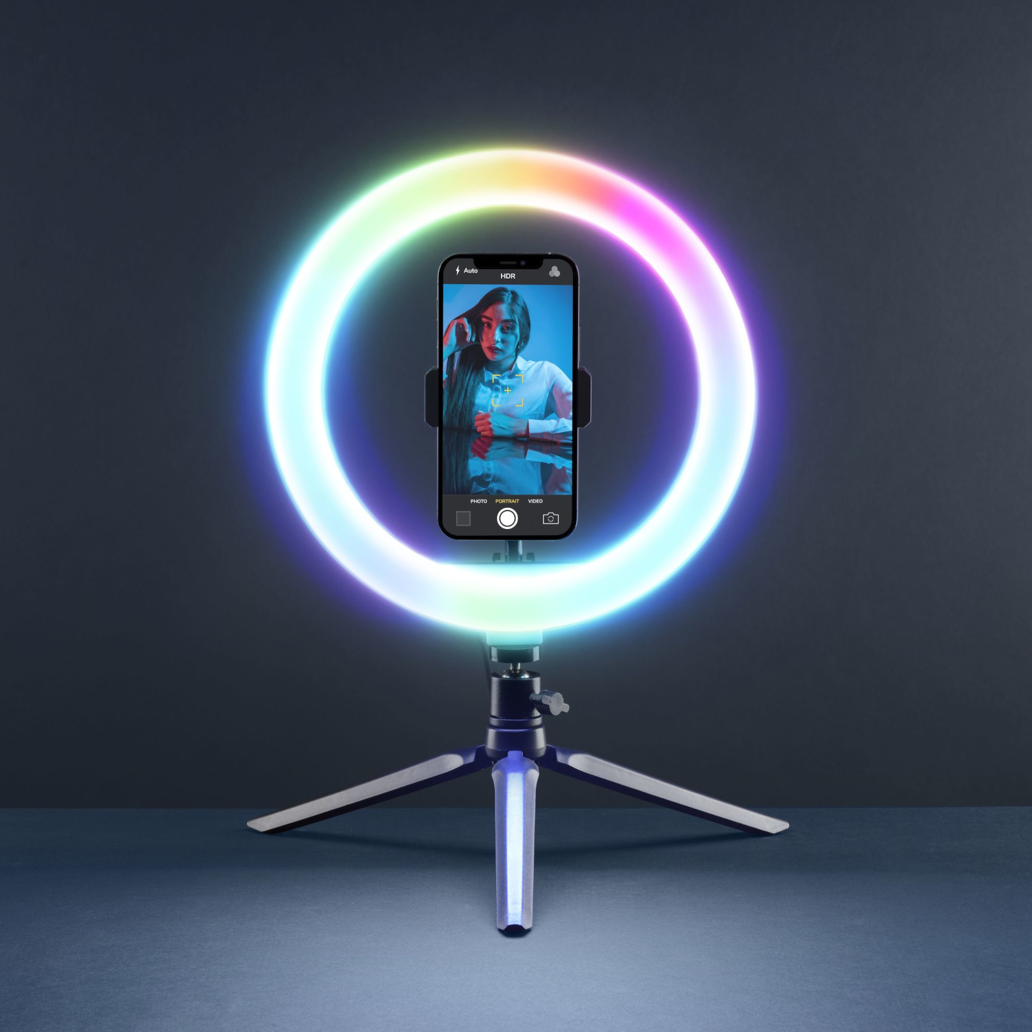 Un teléfono con una luz de anillo para selfies y un trípode.