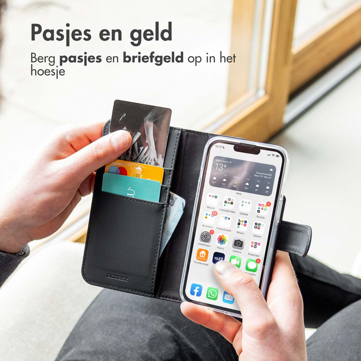 Hände einer Person, die ein Telefon und eine Brieftasche mit Karten halten.