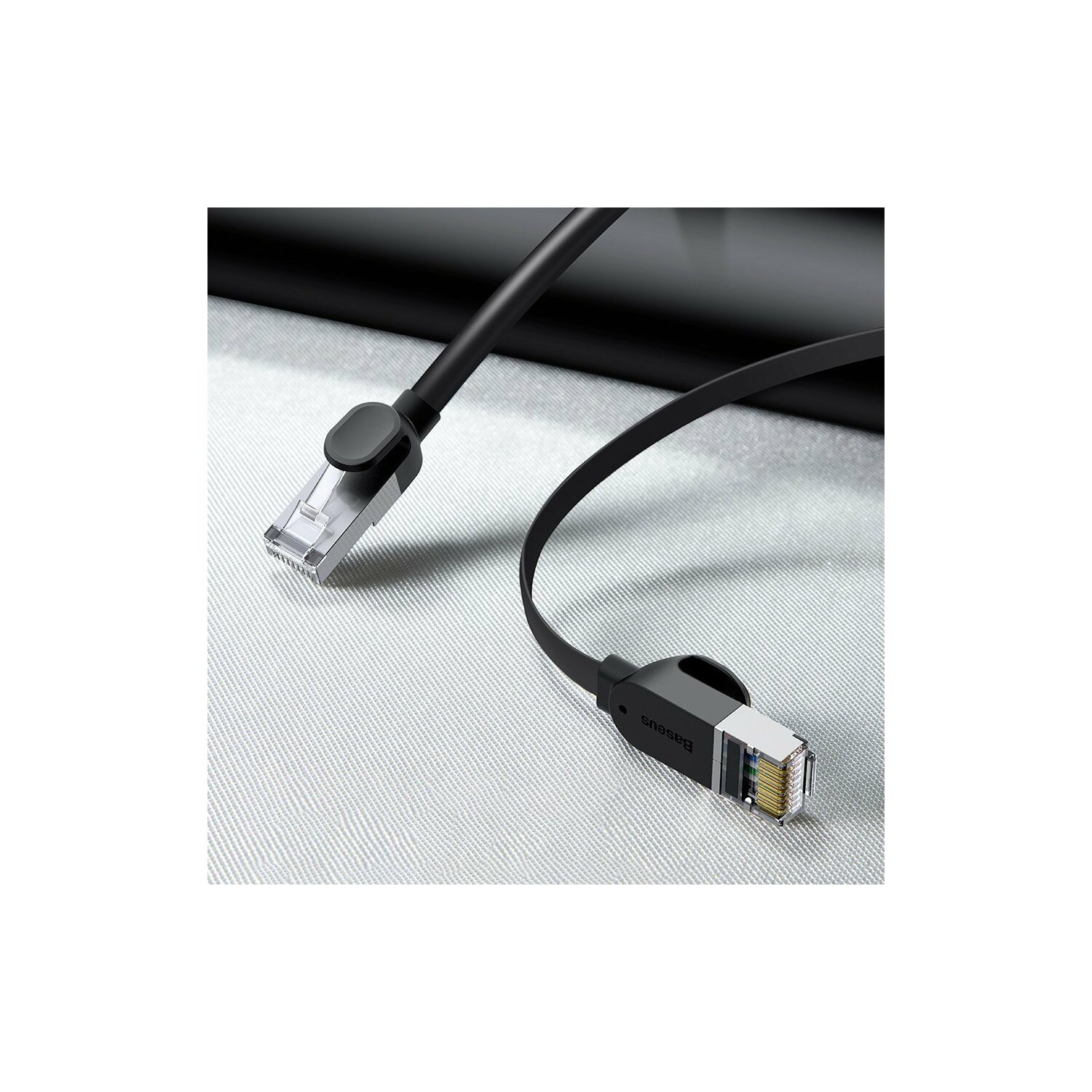Cavo Ethernet nero con connettori, su una superficie chiara.