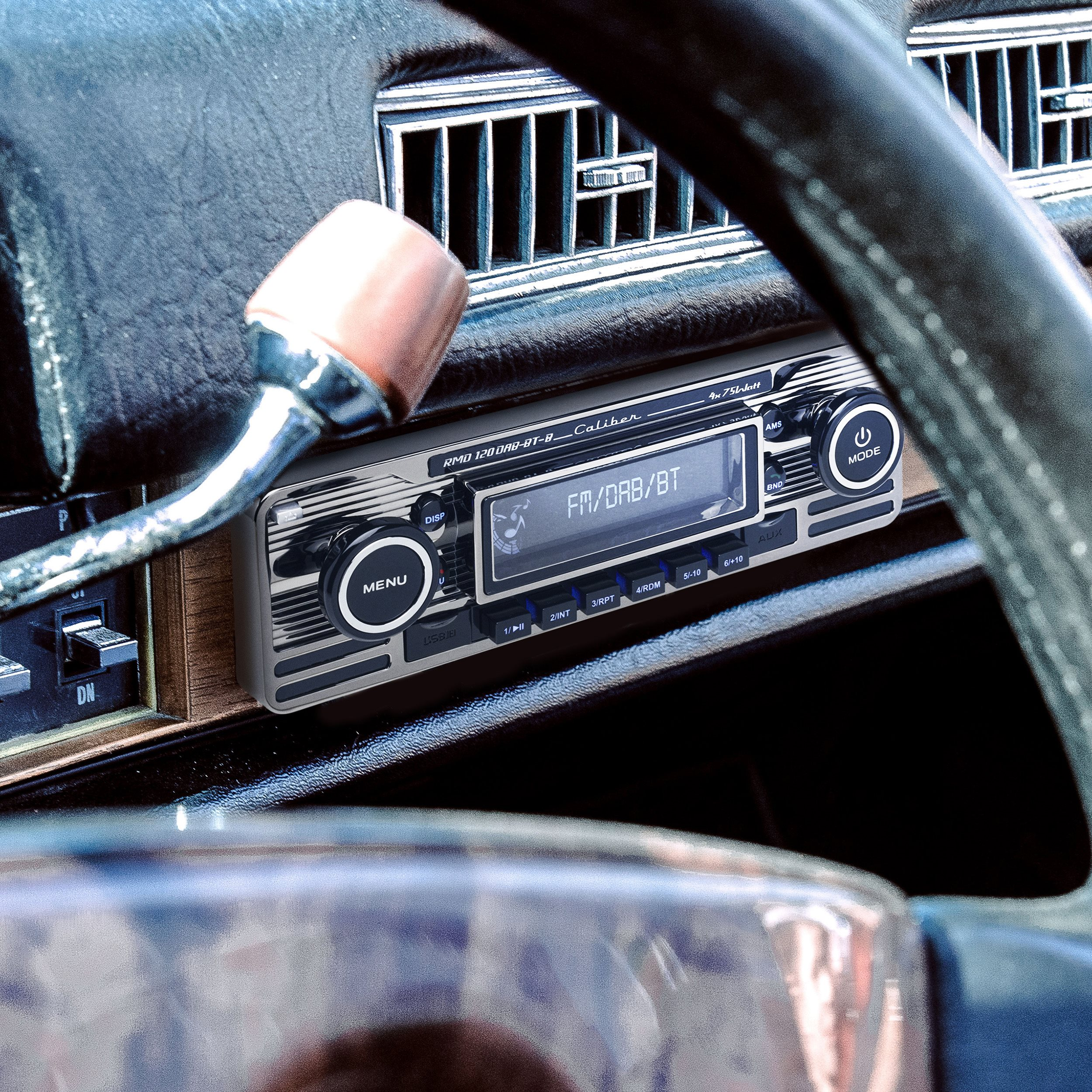 An old car radio with FM/DAB/BT display. Steering wheel and dashboard are in view.