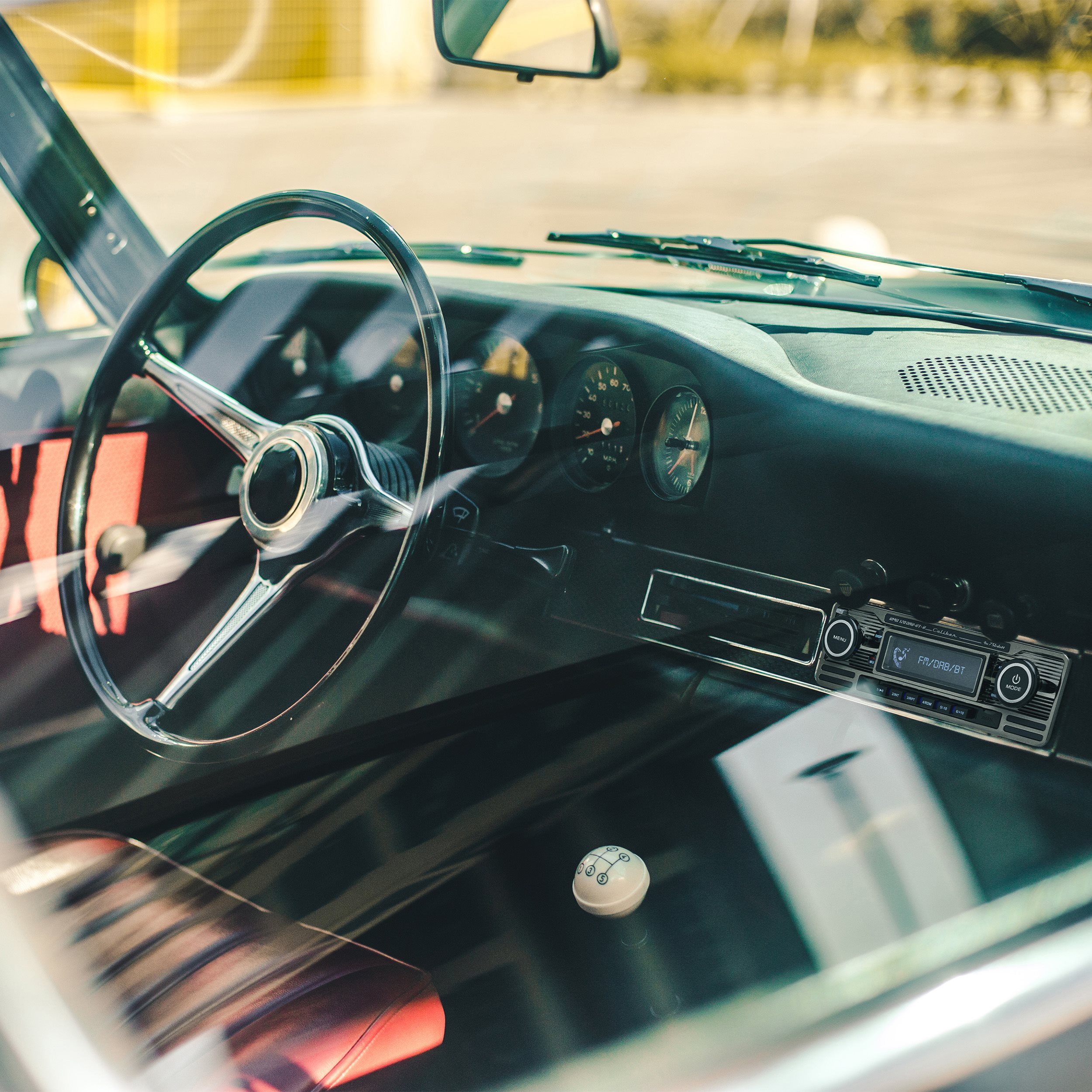 Klassisches Autointerieur mit Lenkrad, Armaturenbrett und Schalthebel.