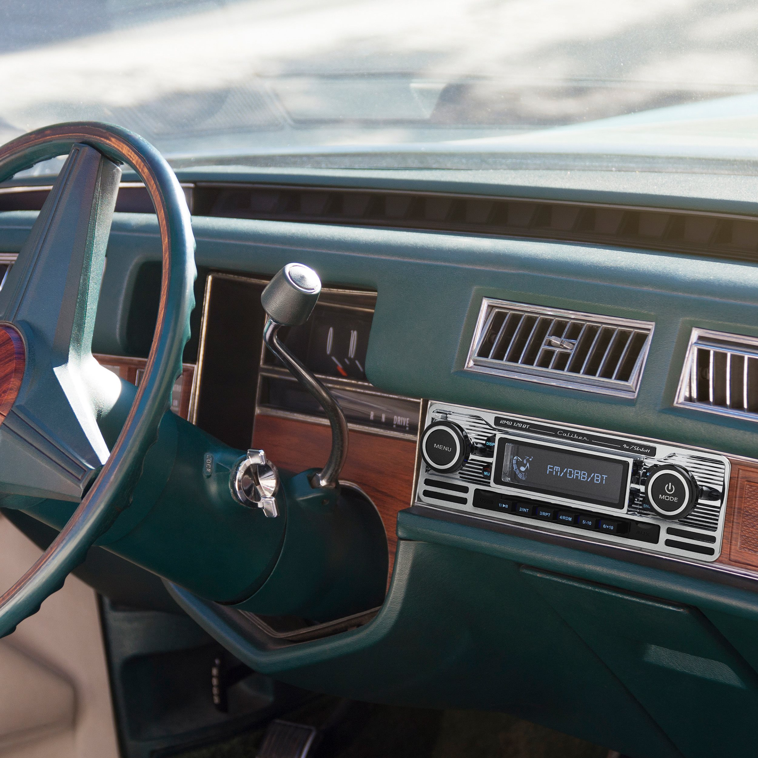 The interior of a teal car. The steering wheel and dashboard are visible.