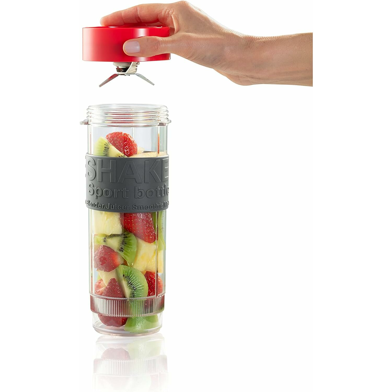 Hand und Blenderaufsatz über einer mit Früchten gefüllten Sportflasche. Früchte: Erdbeere, Kiwi, Ananas.
