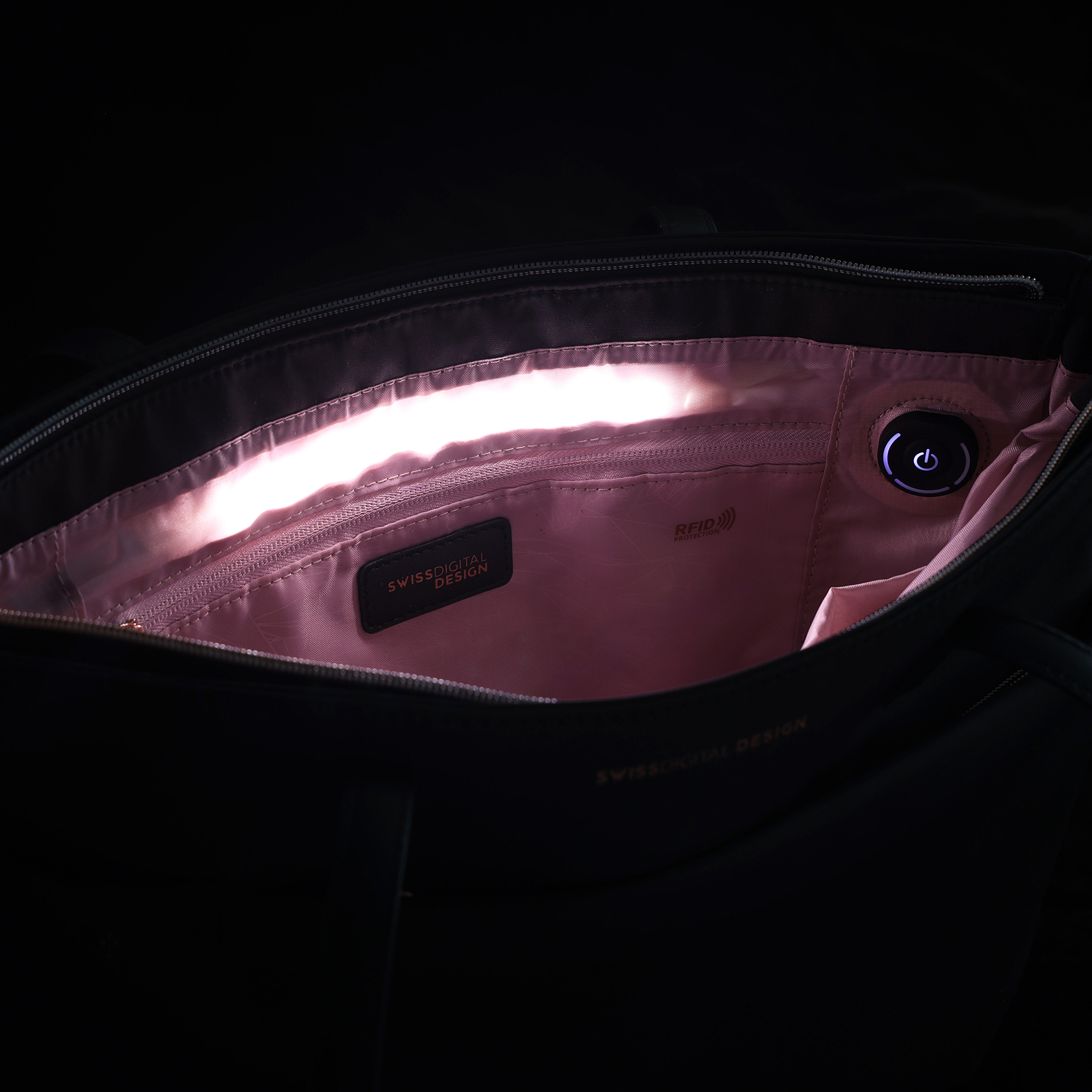 All'interno di una borsa nera. Interno rosa, cerniera e pulsante di accensione visibili.