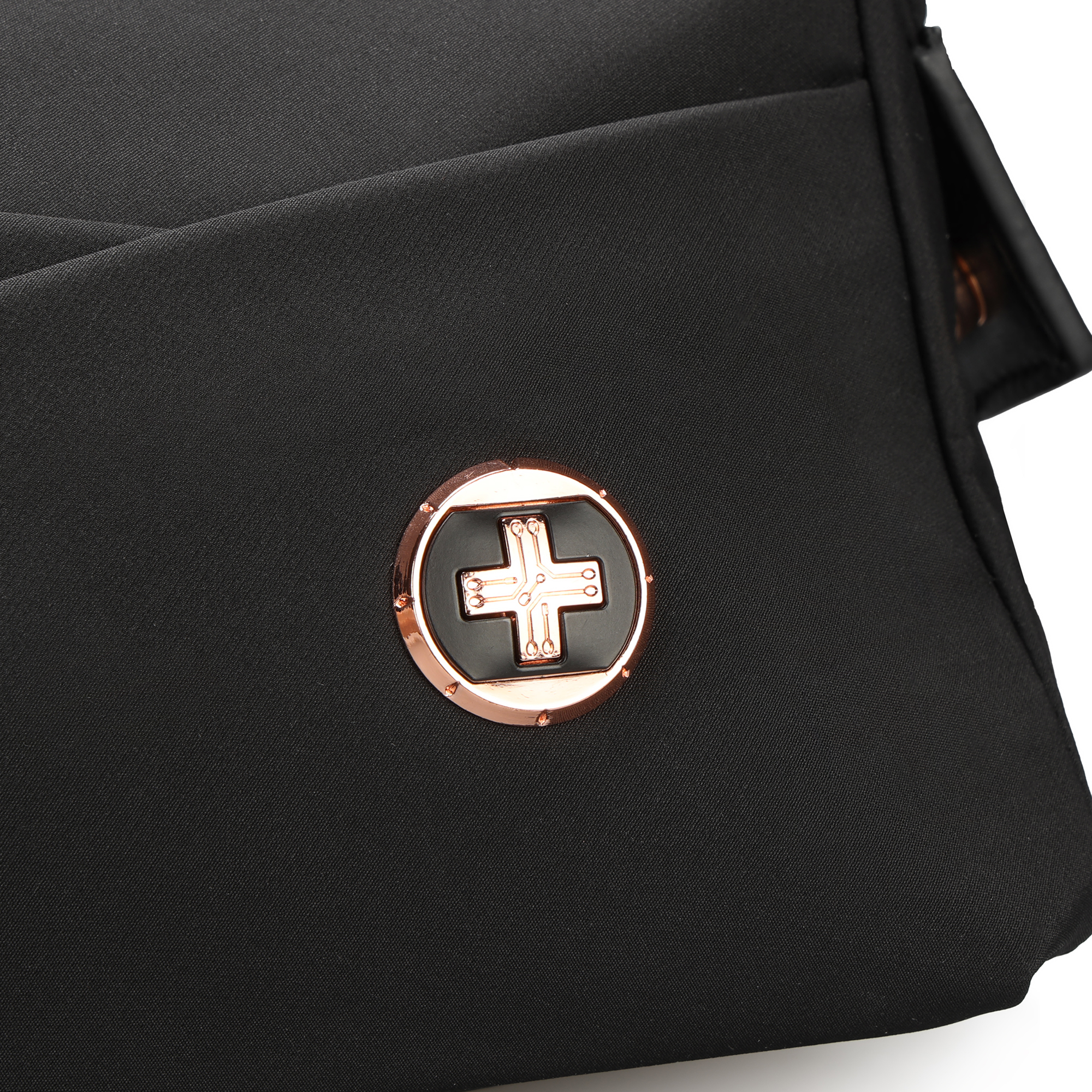 Borsa nera con un emblema a croce svizzera in oro rosa sul davanti, primo piano.