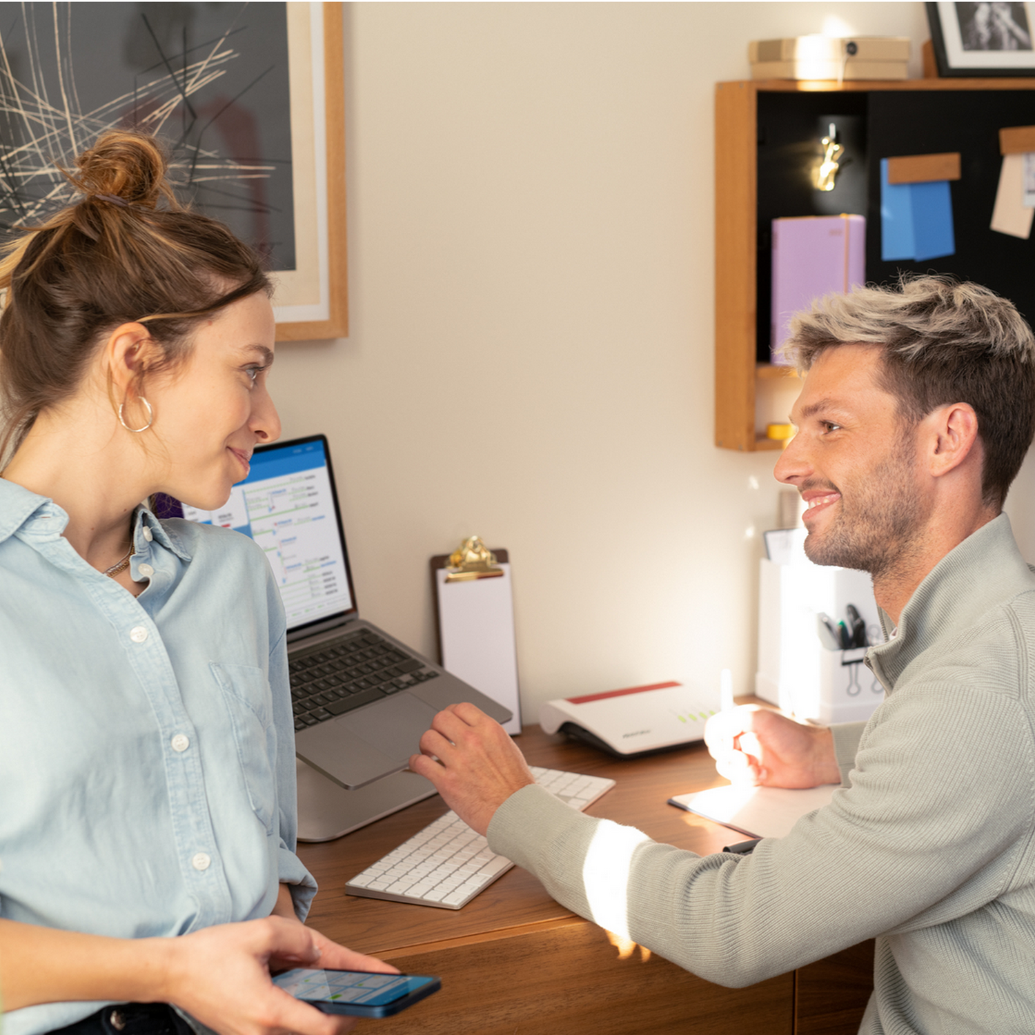 Mężczyzna i kobieta przy biurku, patrzący na laptopa.