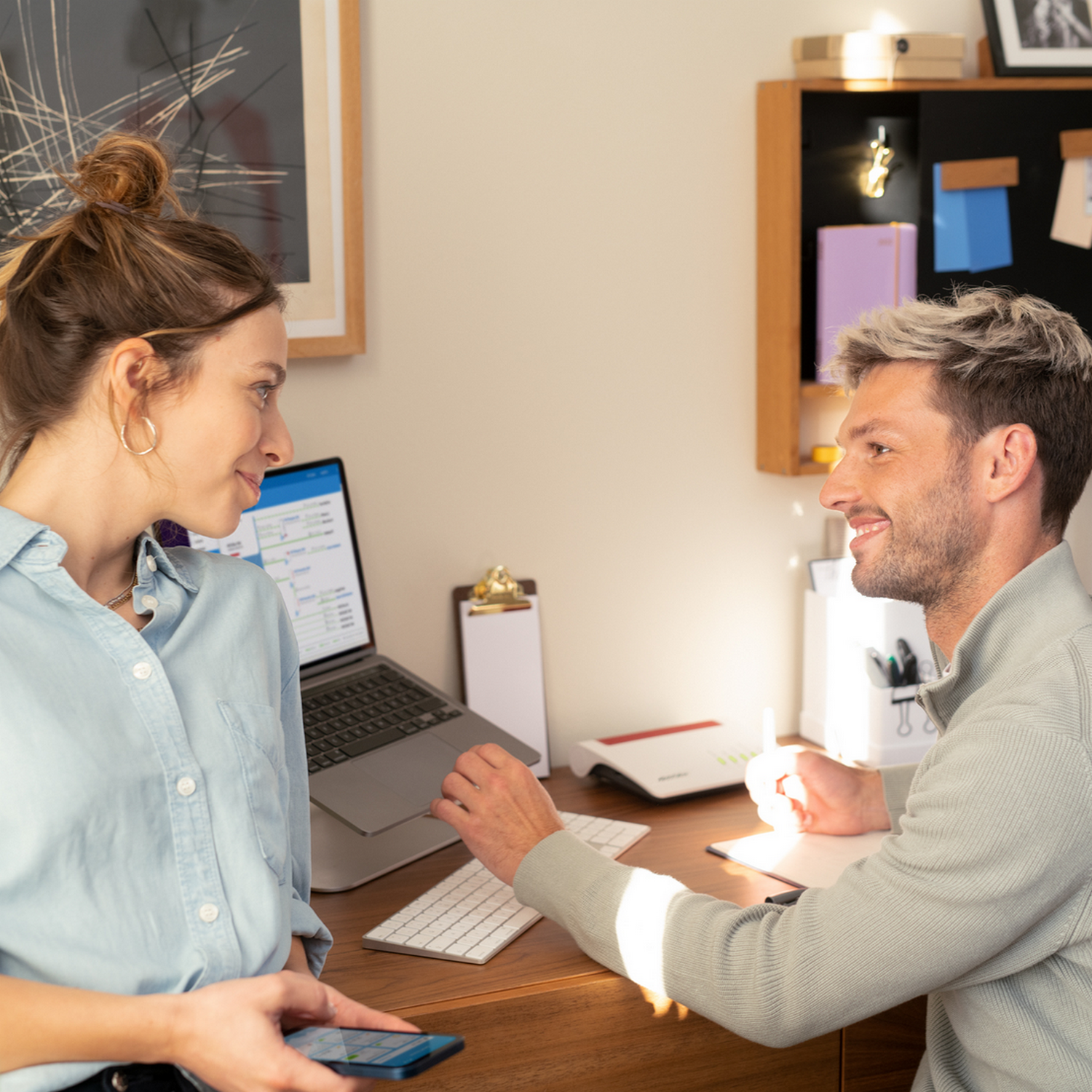 Man en vrouw aan een bureau, kijken naar een laptop.
