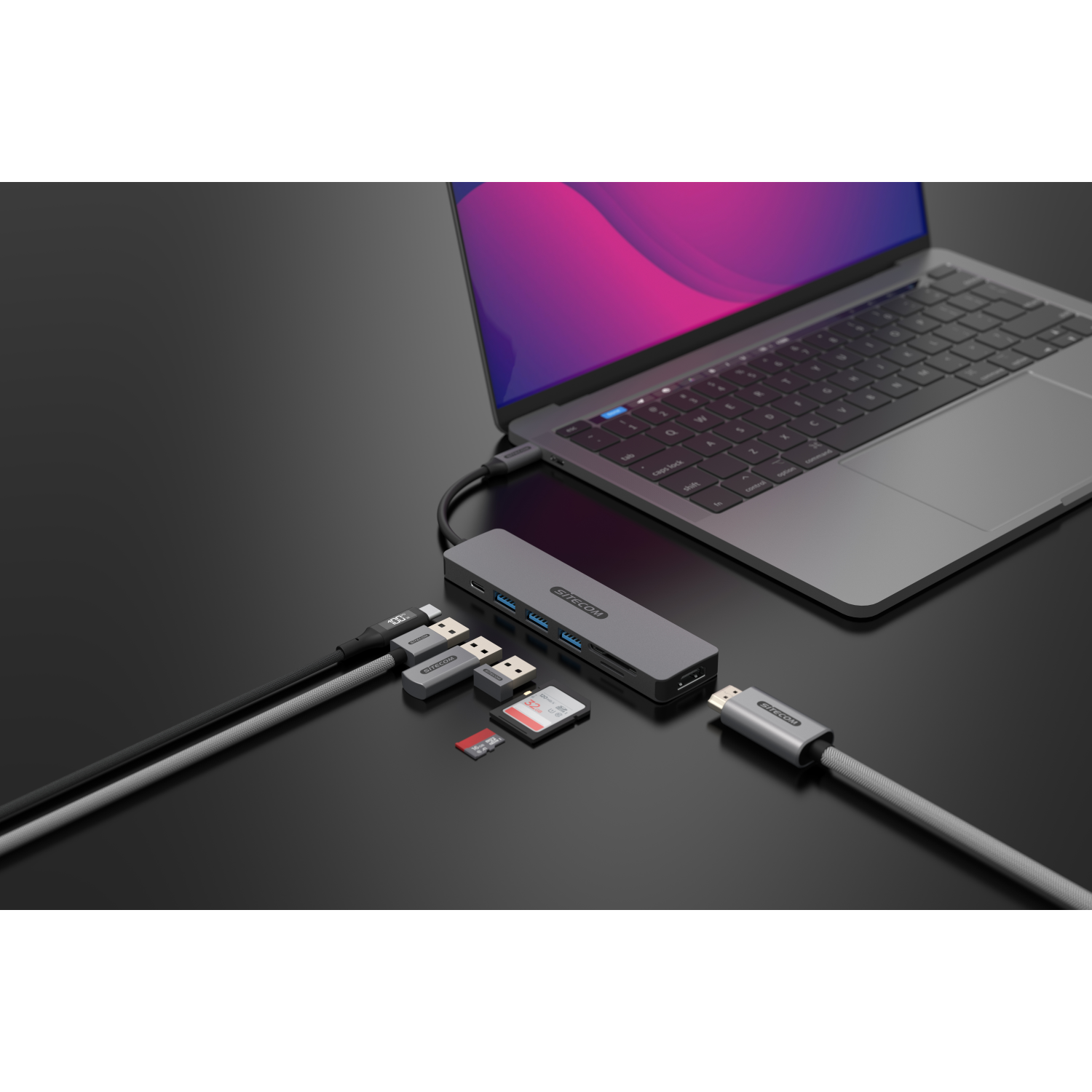 Laptop, hub e vari cavi. L'hub è collegato al laptop. Sono collegati anche altri dispositivi.
