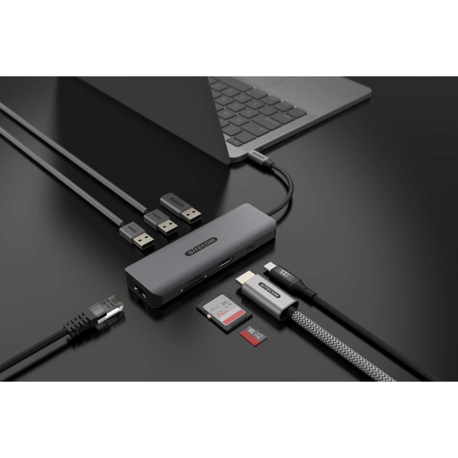 Hub USB-C Sitecom grigio con cavi, scheda SD e laptop. Diverse porte sono visibili.
