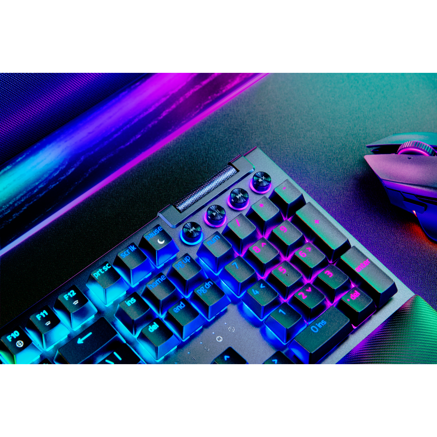 Zbliżenie klawiatury dla graczy. Podświetlane na niebiesko, różowo i fioletowo klawisze.
