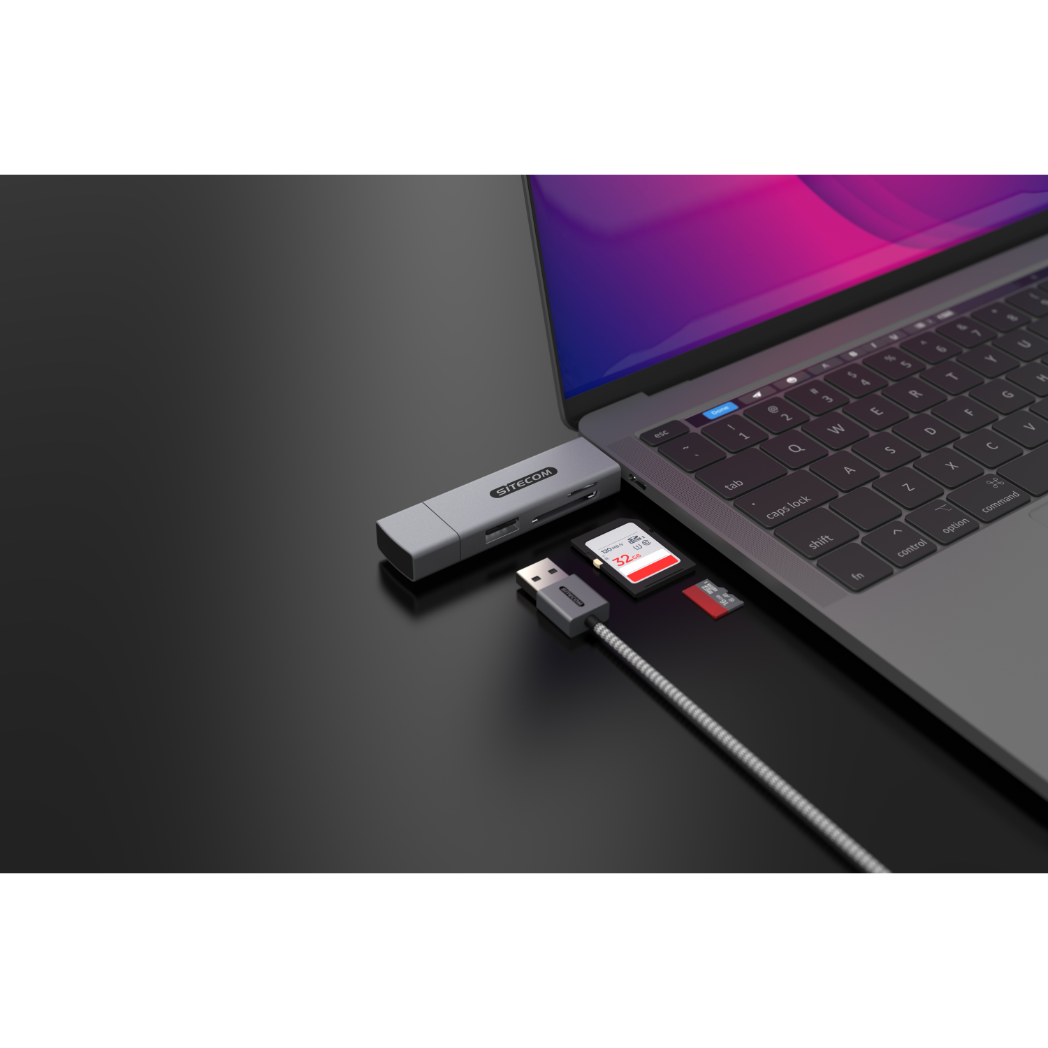 Laptop mit Kartenleser, USB-Kabel, SD-Karte und schwarzem Hintergrund.