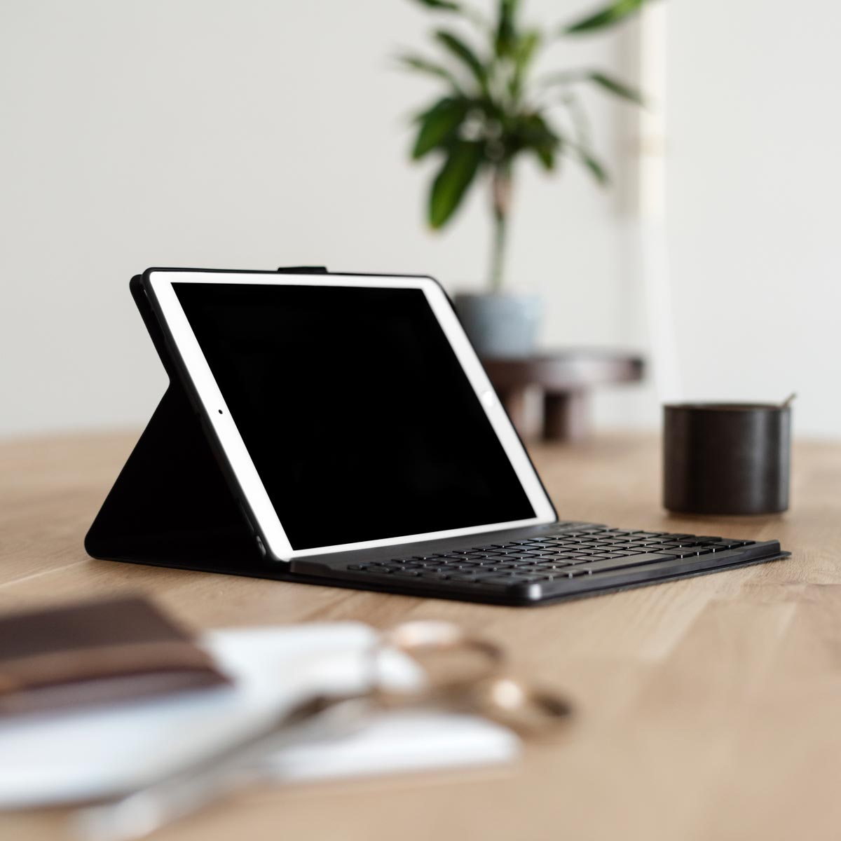 Een tablet met een toetsenbord op een houten tafel.