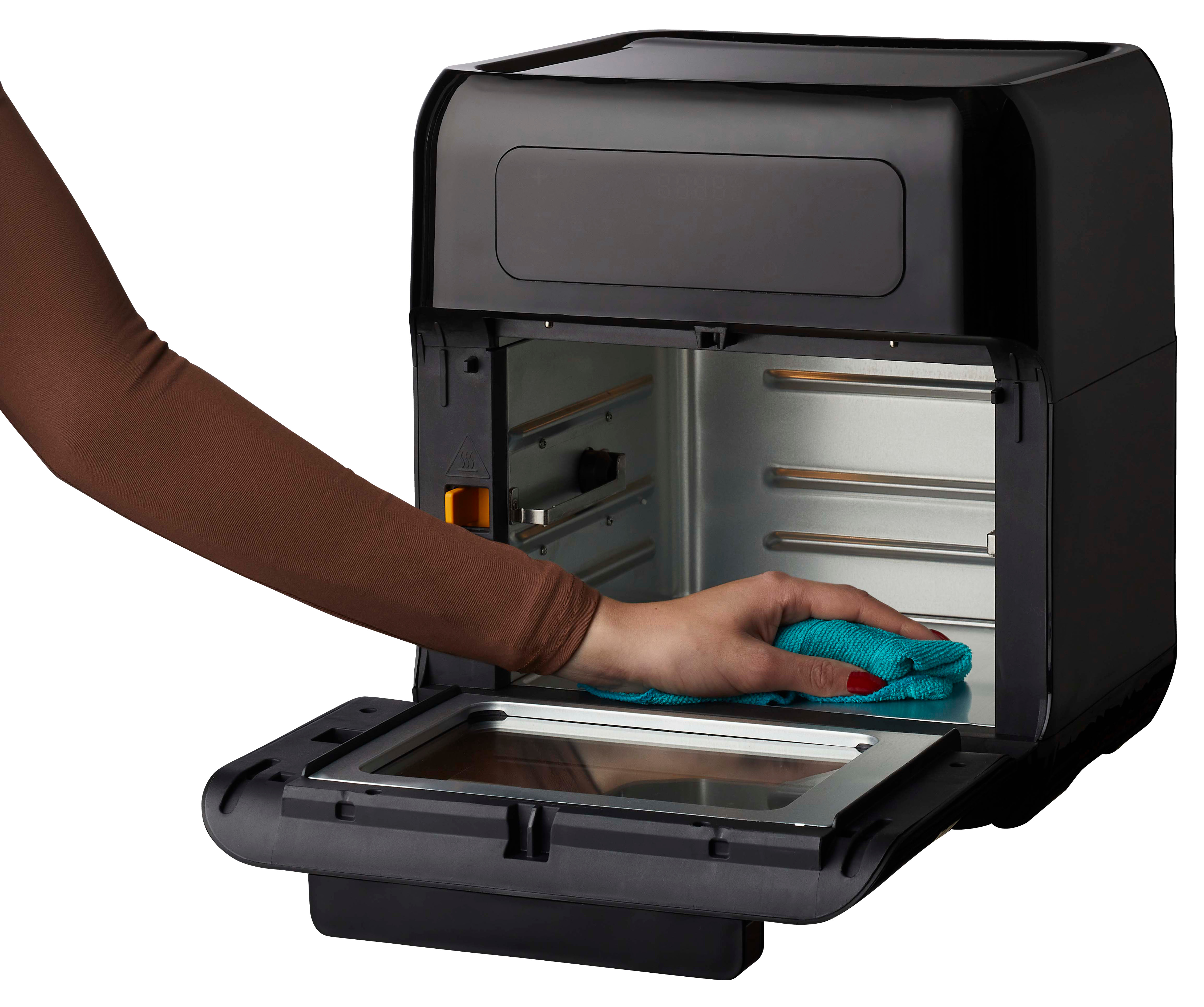Black air fryer, open, with a person cleaning the inside with a cloth.