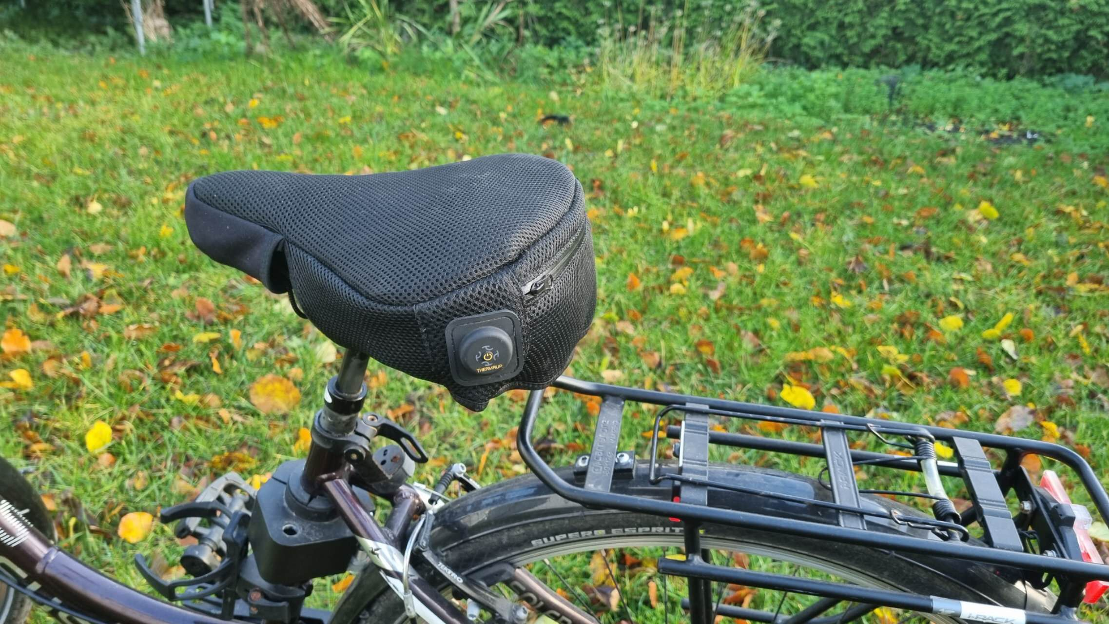 Schwarzer Mesh-Fahrradsattel mit Licht und Gepäckträger am Fahrrad.