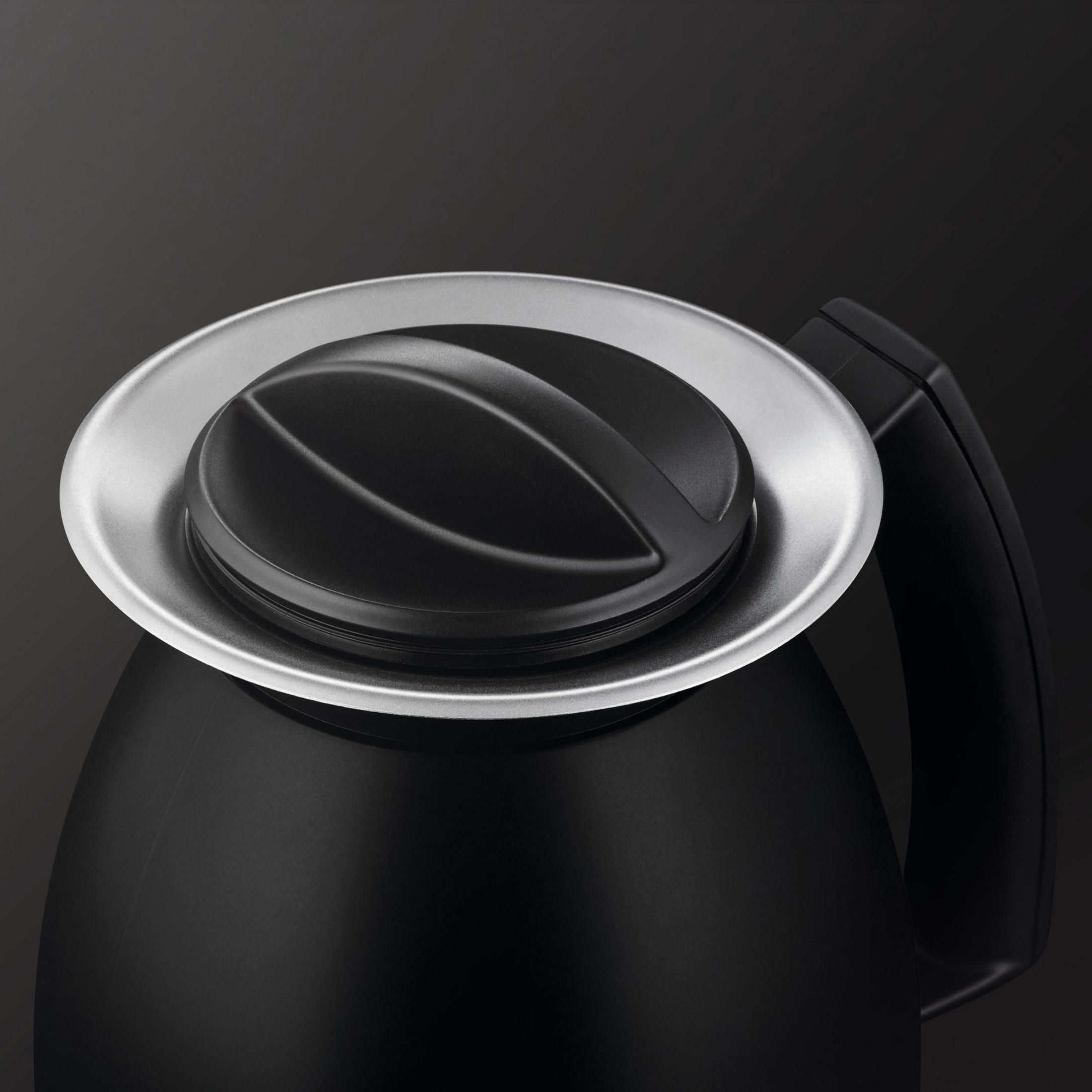 Czarna pokrywa i uchwyt ekspresu do kawy. Srebrna obwódka otacza pokrywę.