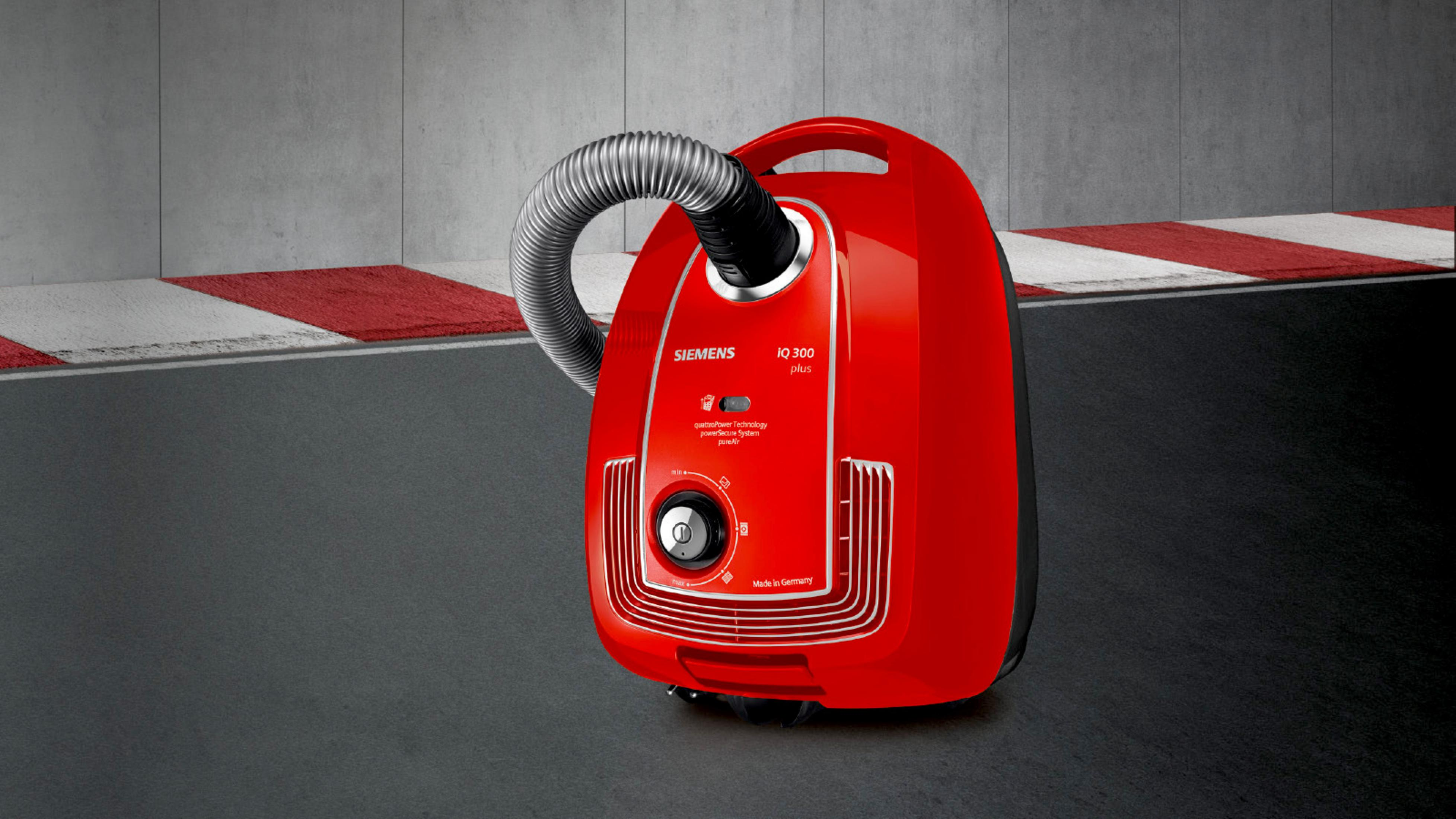 Roter Siemens Staubsauger auf grauem Untergrund mit Rennstreifen.