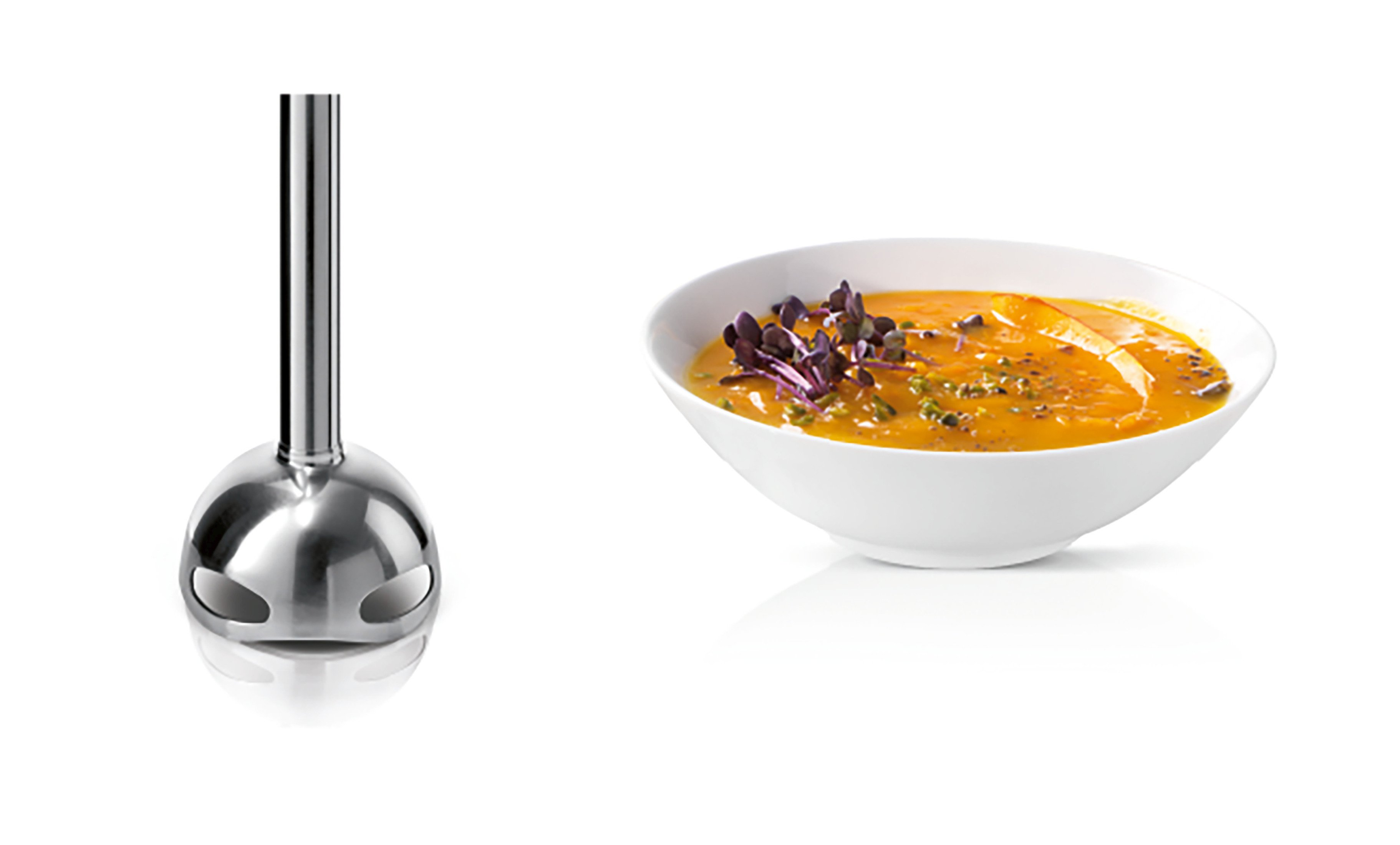 Stafmixer naast een witte kom met oranje soep met garnering.