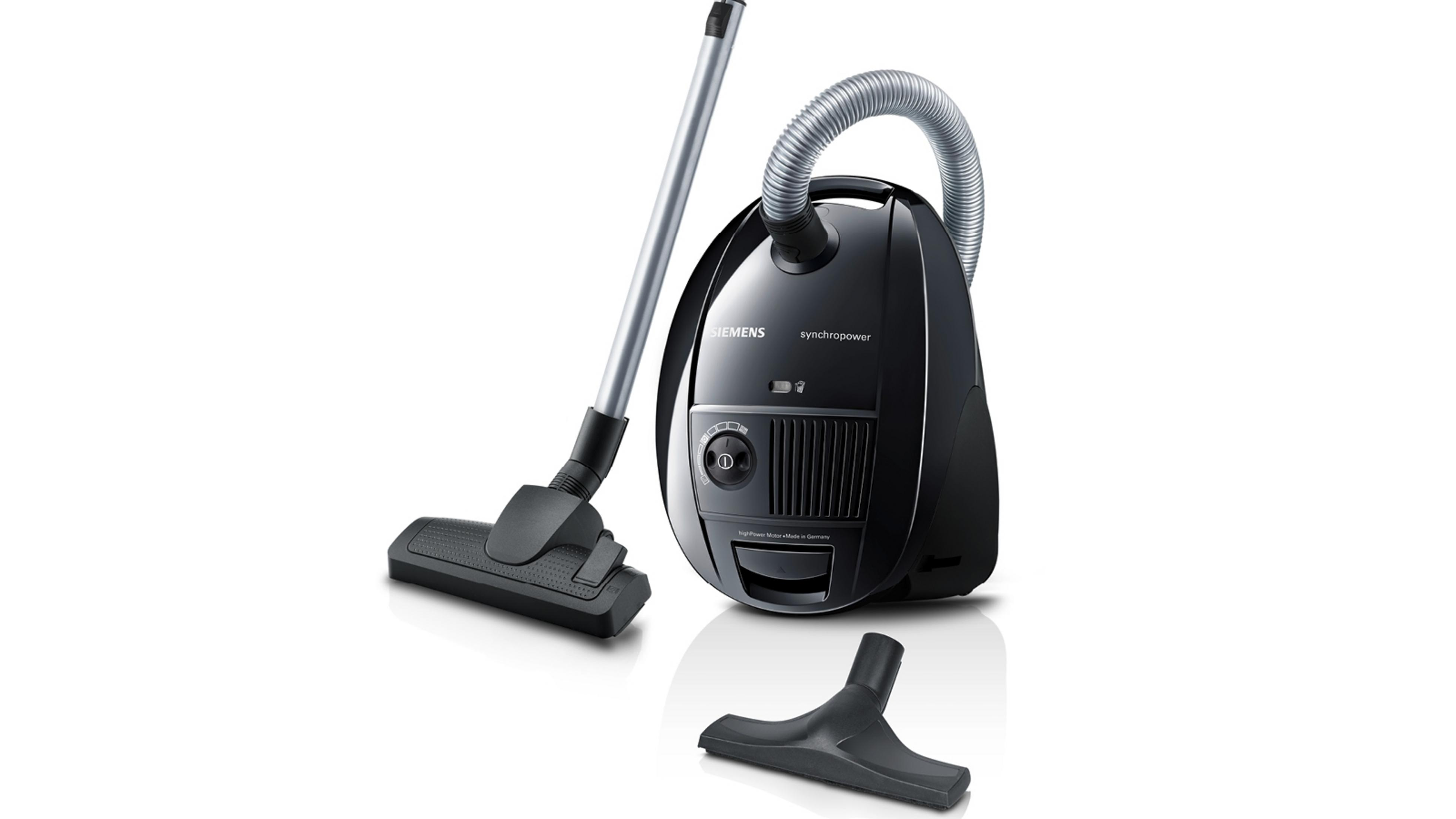 Czarny odkurzacz z przystawkami na białym tle.