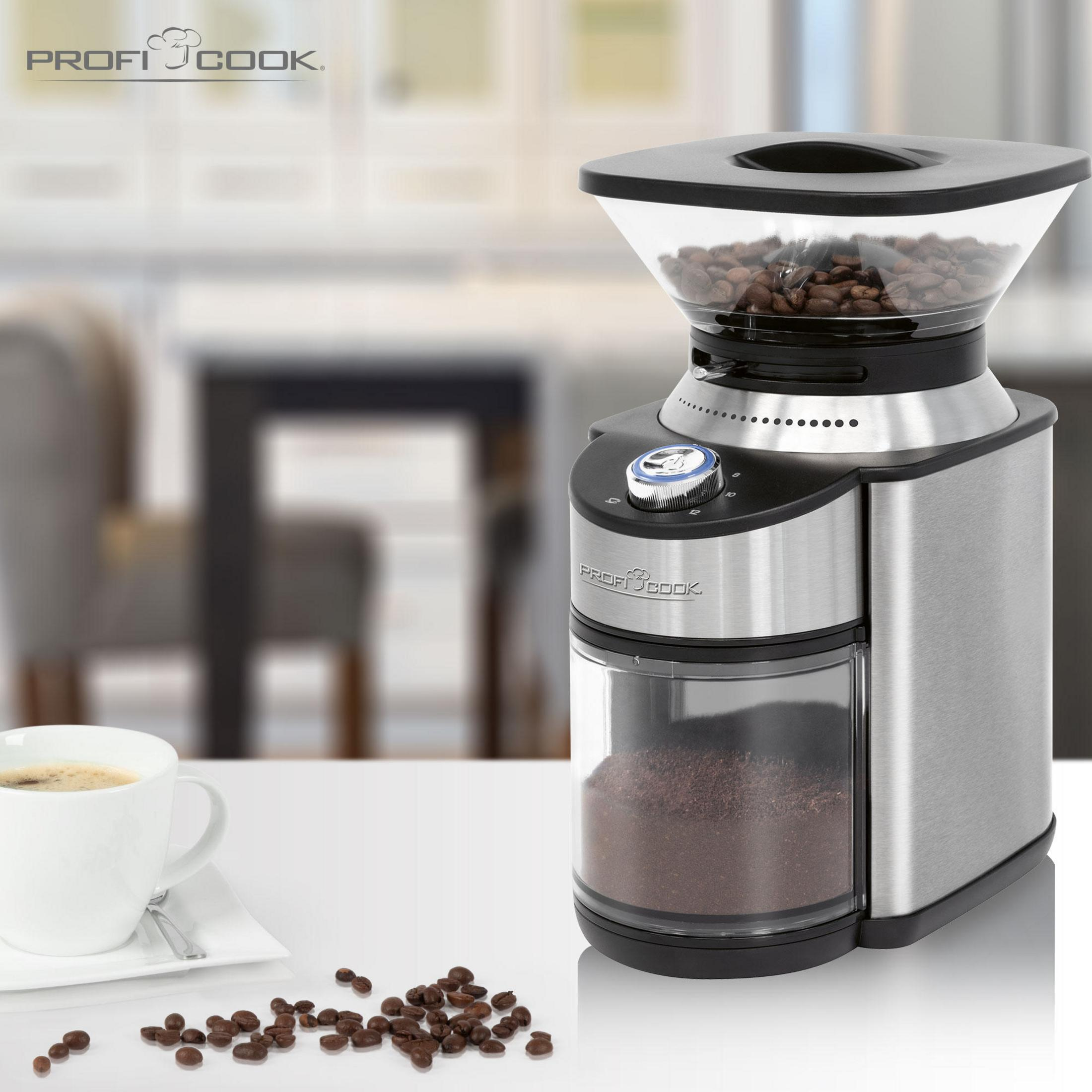 Młynek do kawy z ziarnami i zmieloną kawą, filiżanka kawy na stole.