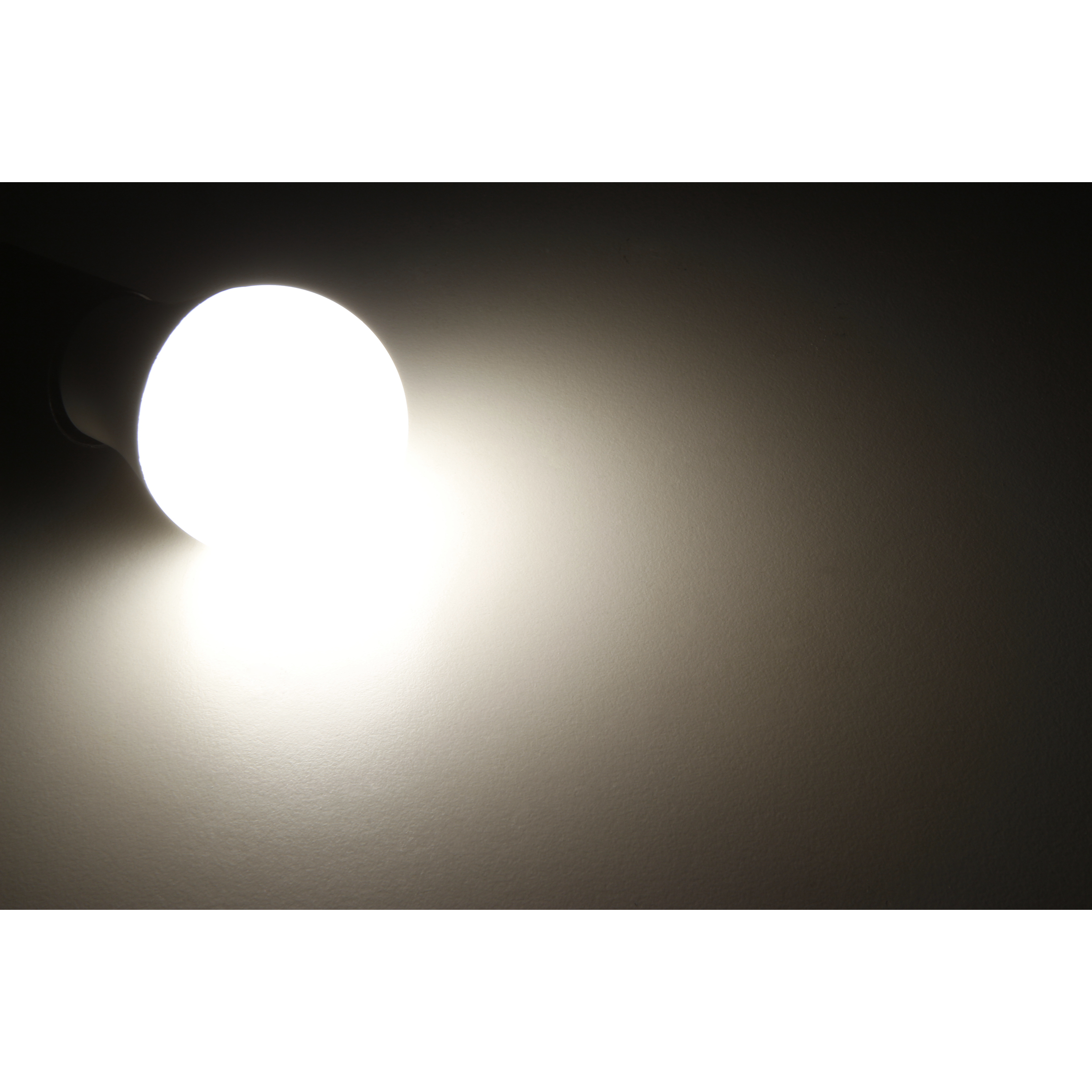 Eine leuchtende Glühbirne vor dunklem Hintergrund. Das Licht ist hell und beleuchtet die Umgebung.